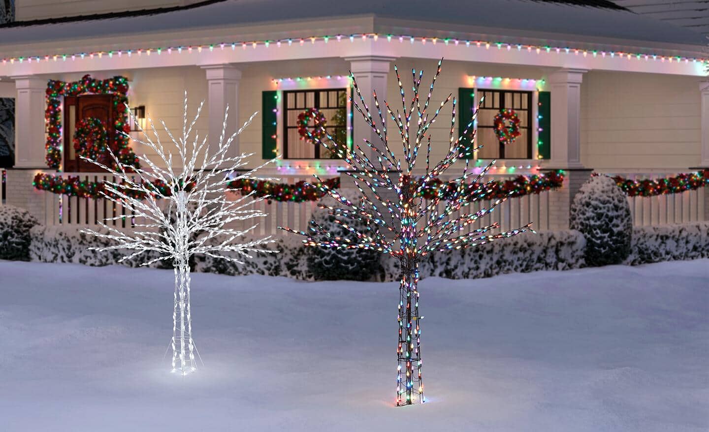 Lit Christmas decor stands in a snowy yard. Lit Christmas decor stands in a snowy yard.