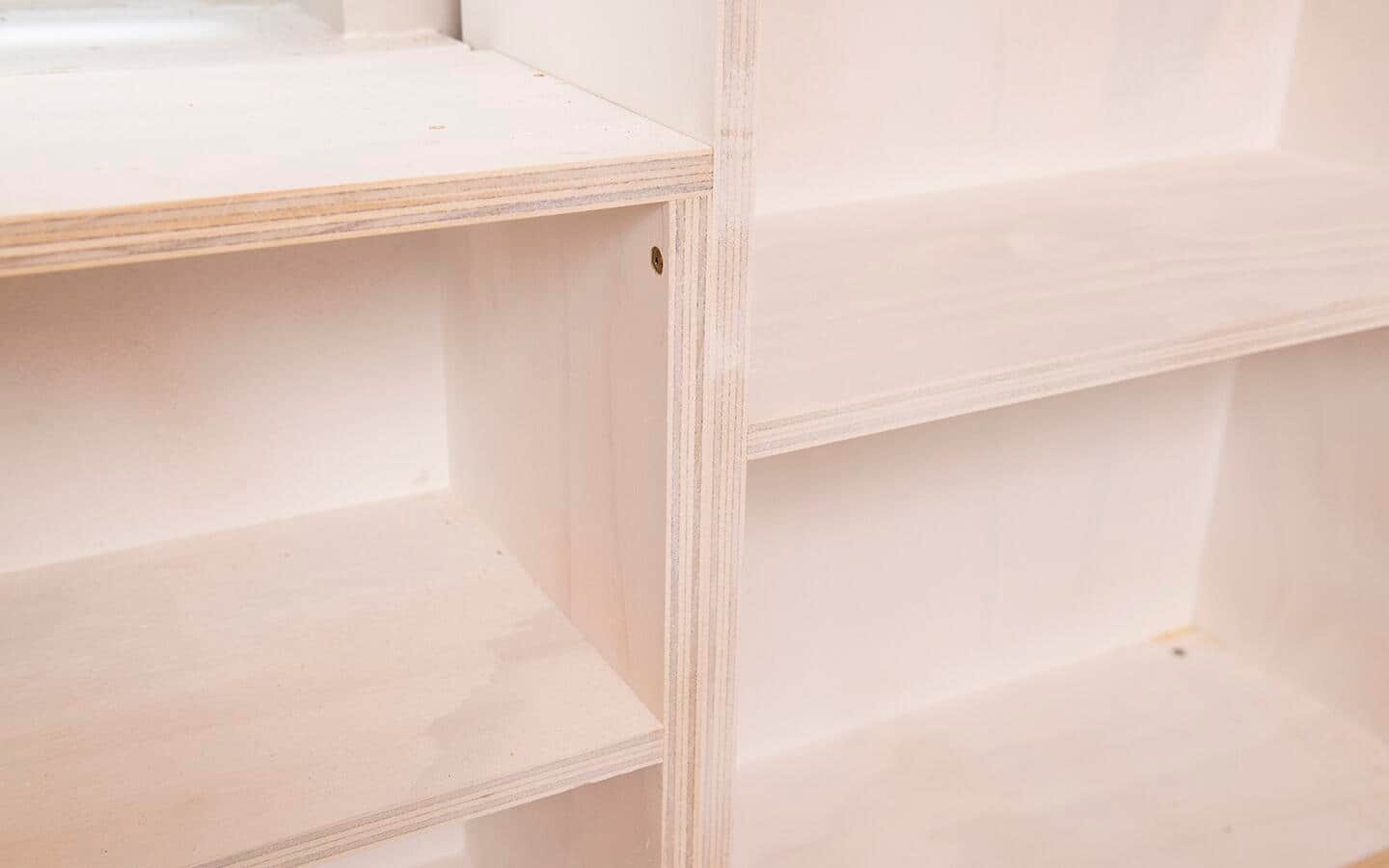 Two sections of a built in shelving unit are connected with a pan head cabinet screw.