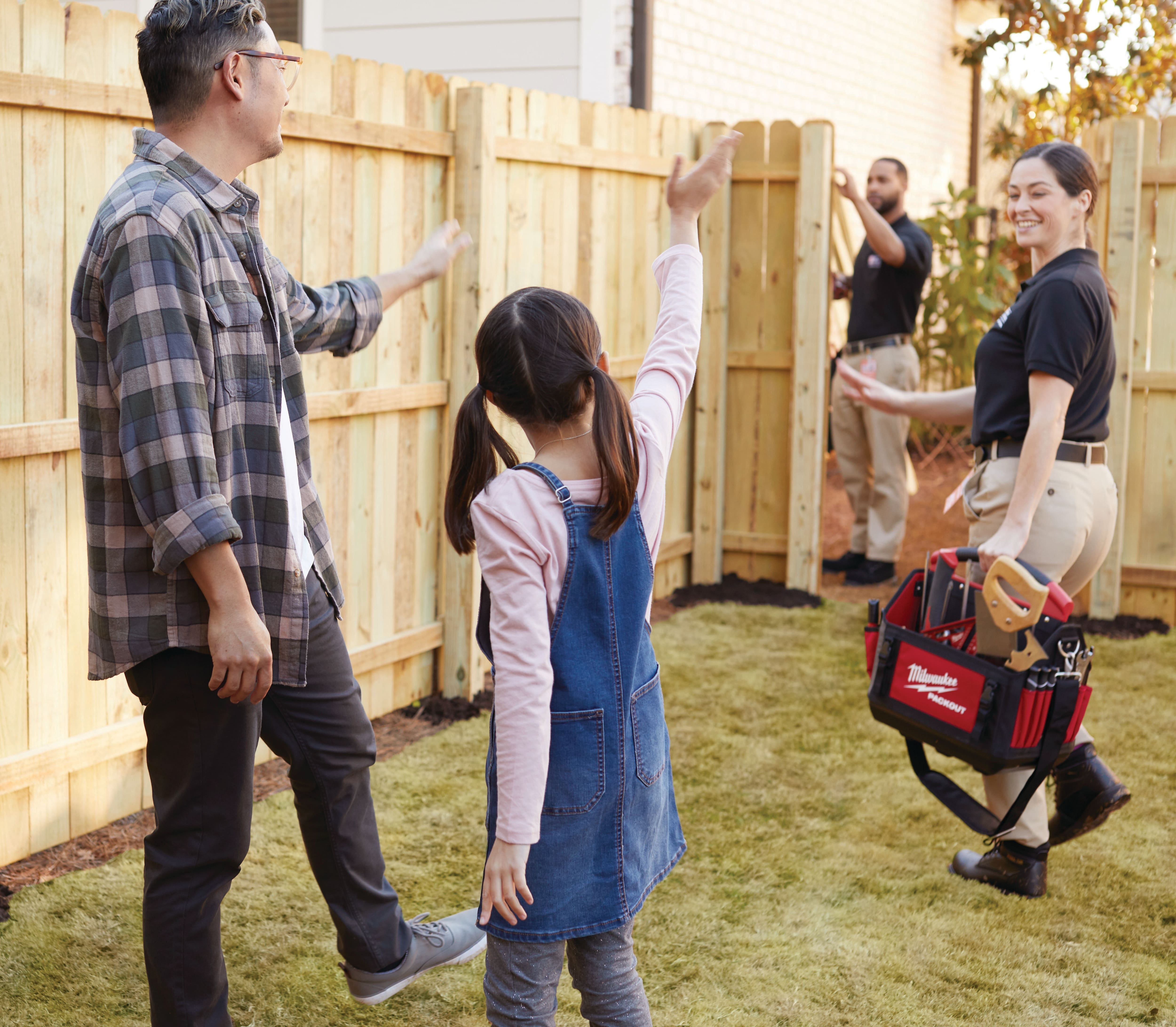 FENCING INSTALLATION IMAGE WITH FATHER/ DAUGHTER WAVING TO TECHS
