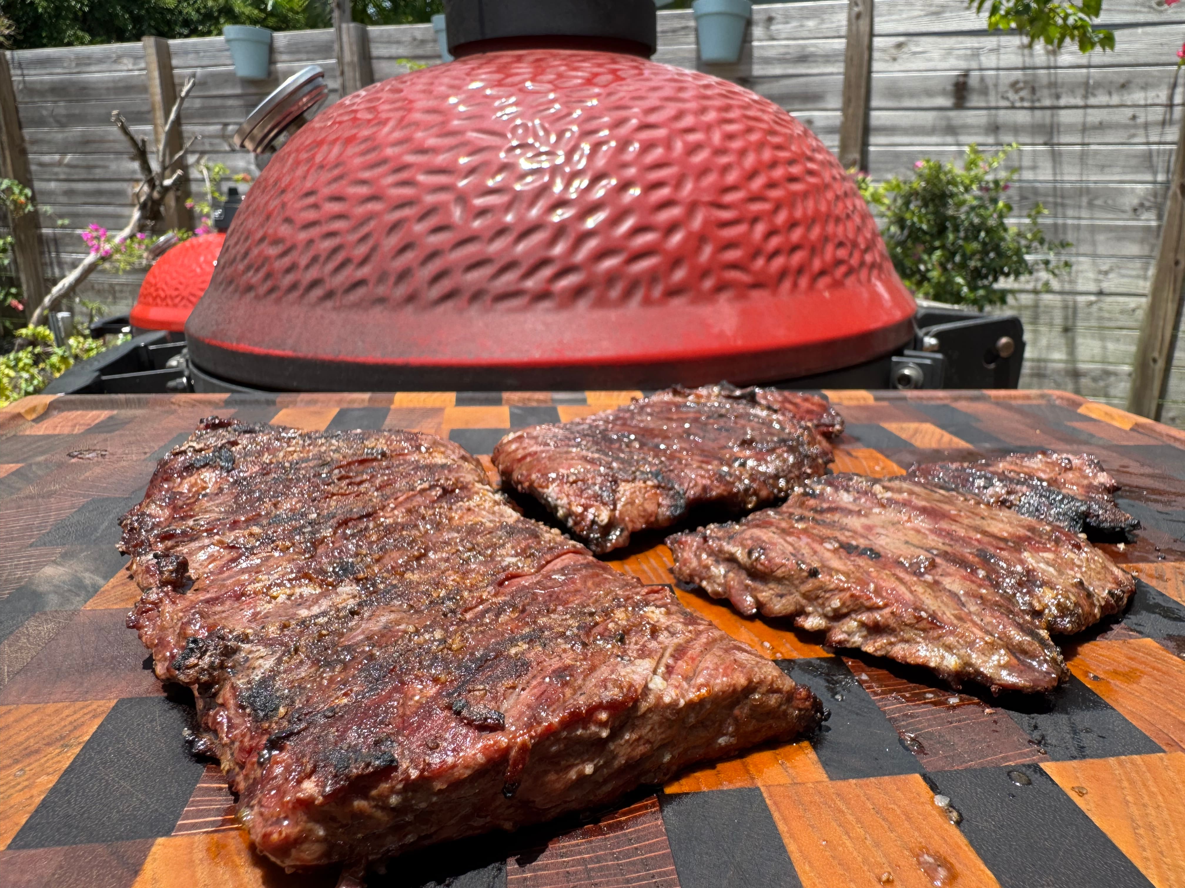 Steak sitting outdoors over a wood cutting board, resting. Steak sitting outdoors over a wood cutting board, resting.