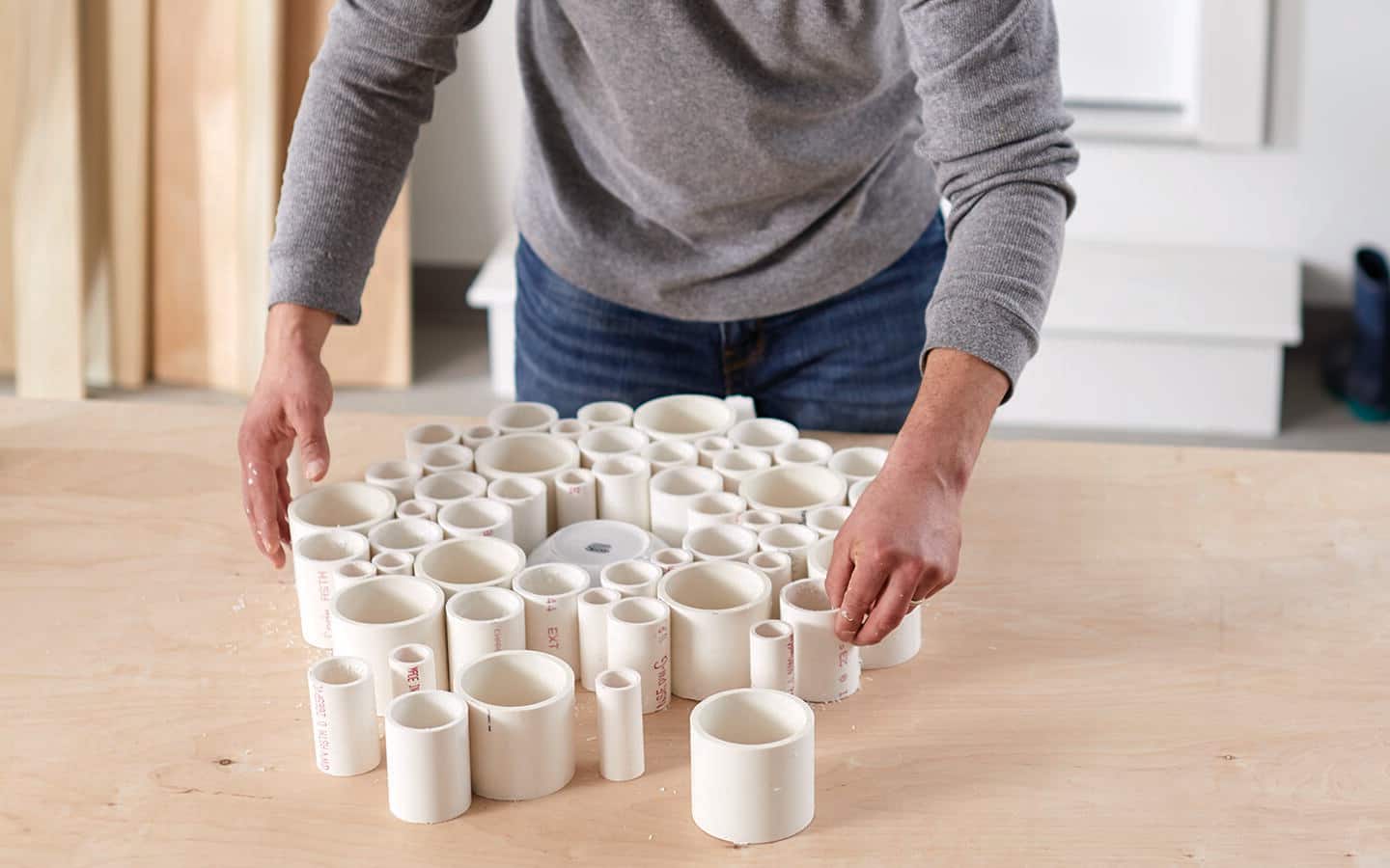 A person arranging the cut PVC pipe into a circle. A person arranging the cut PVC pipe into a circle.