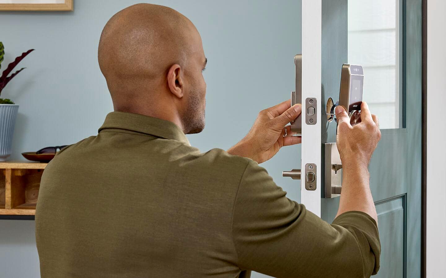 A person installs a smart lock on their door.