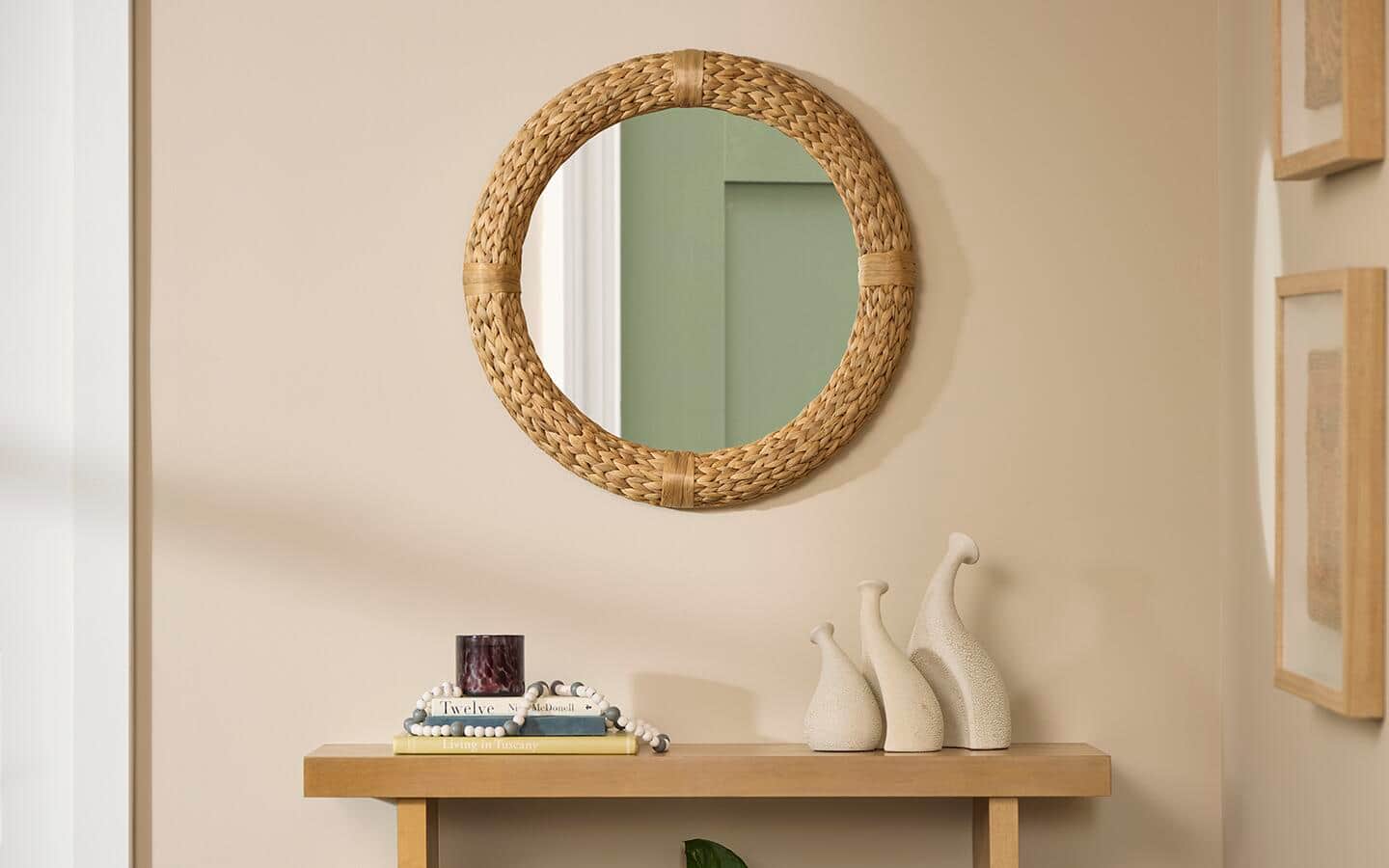 A round wall mirror hangs above a hallway table A round wall mirror hangs above a hallway table