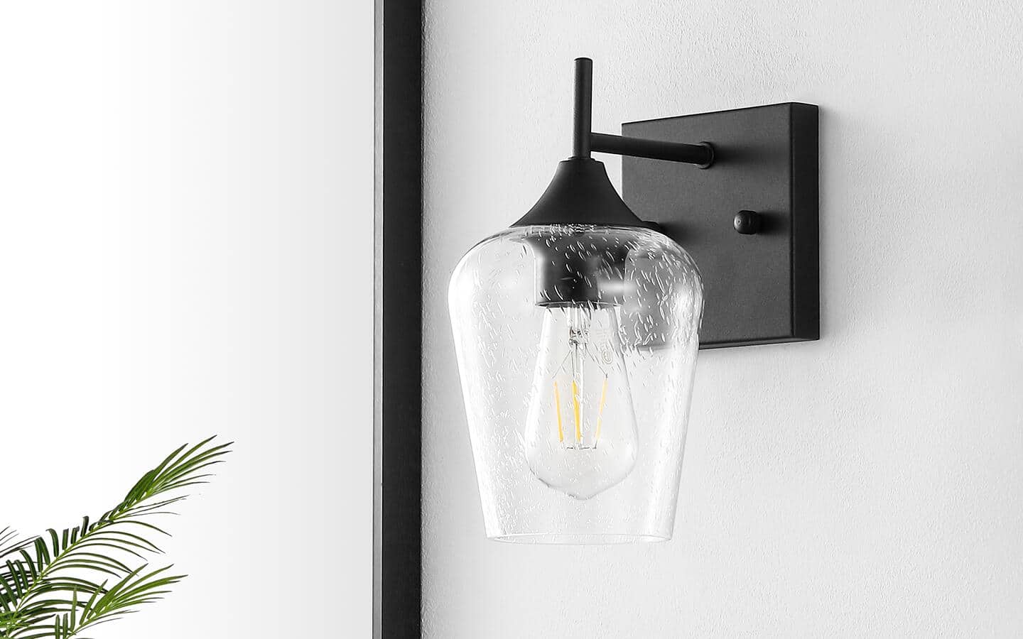 A white bathroom with one sconce installed on a wall. A white bathroom with one sconce installed on a wall.