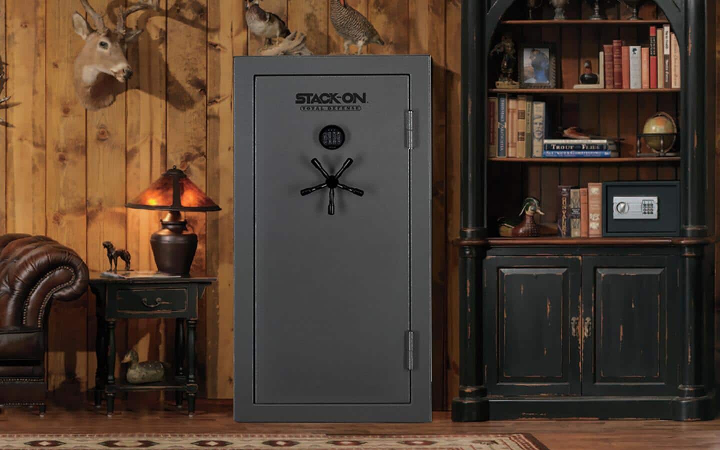 A large, dark gray gun safe beside a bookcase.