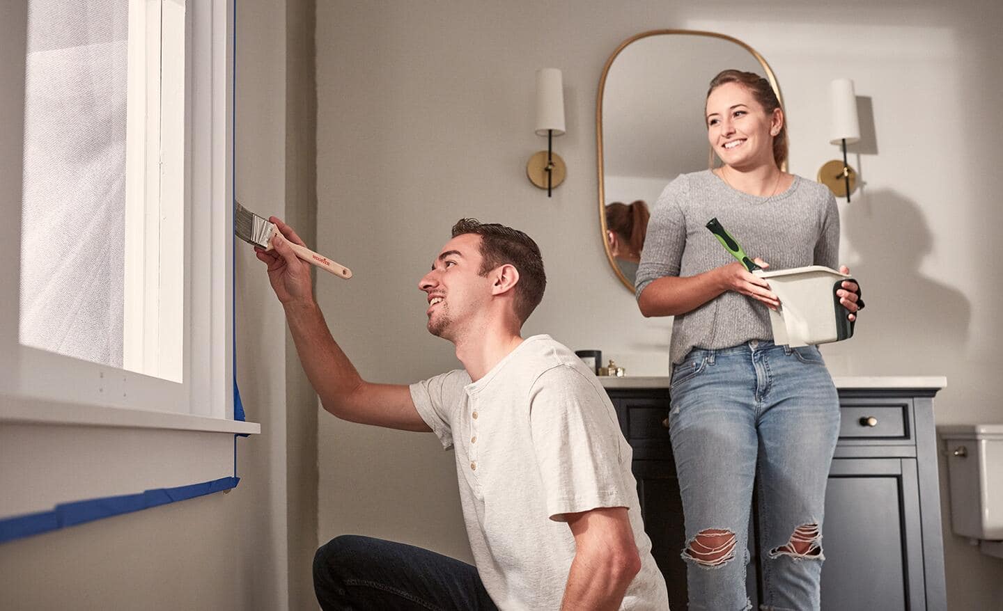 Someone painting a bathroom wall.