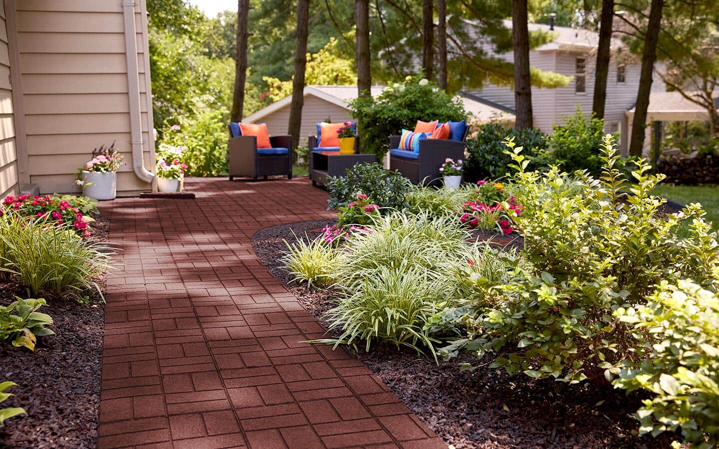 A path made of brick pavers winding through a shady part of a garden. 