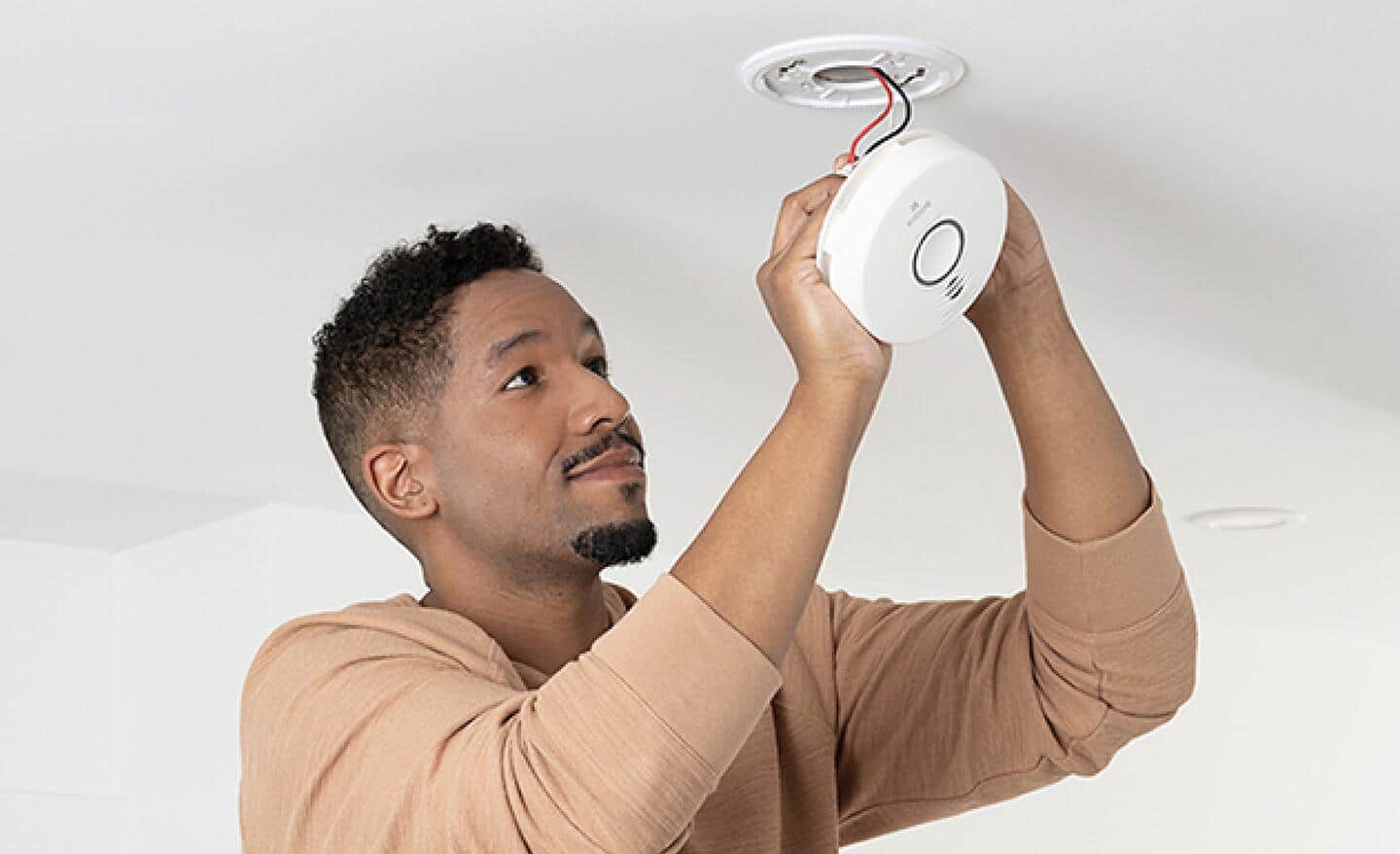 A man installing a carbon monoxide alarm.