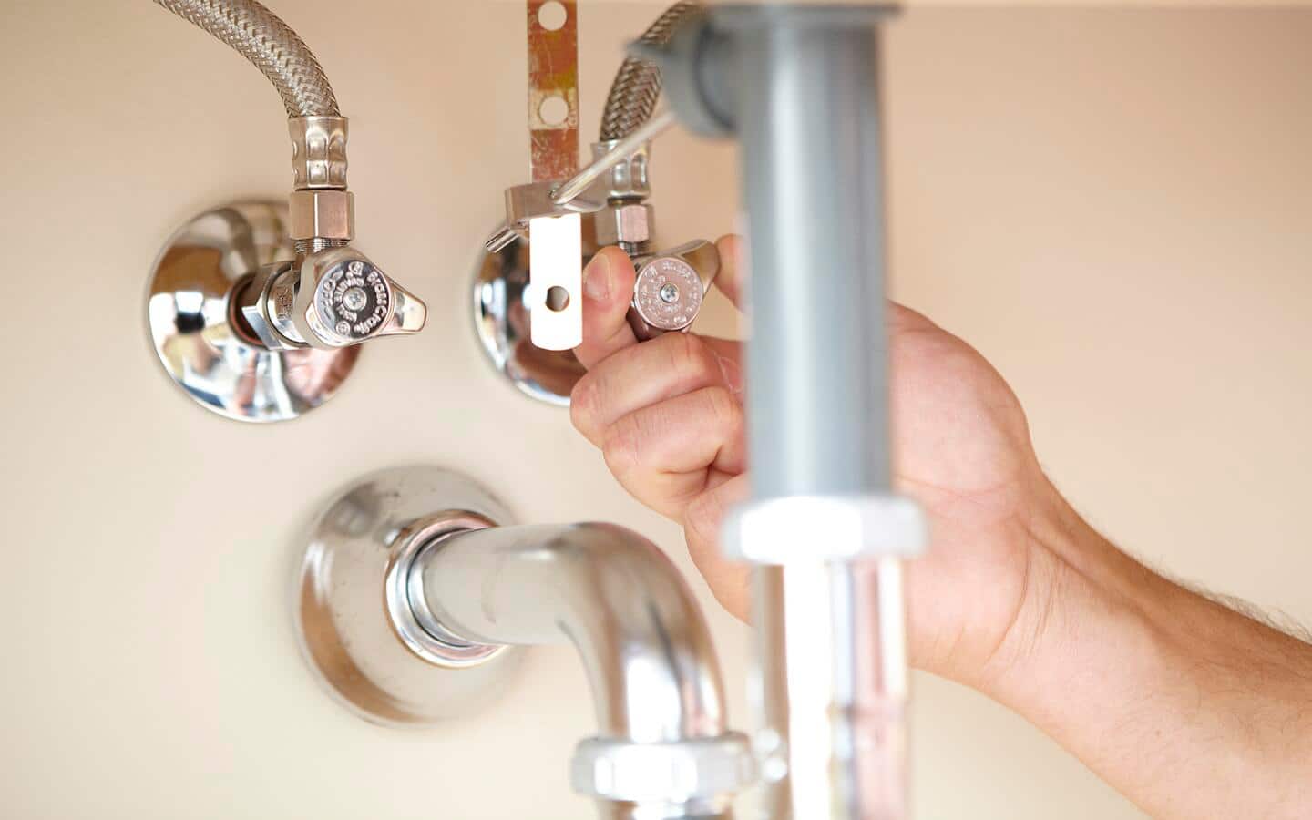 A gauge being turned clockwise to shut off water to a sink. A gauge being turned clockwise to shut off water to a sink.
