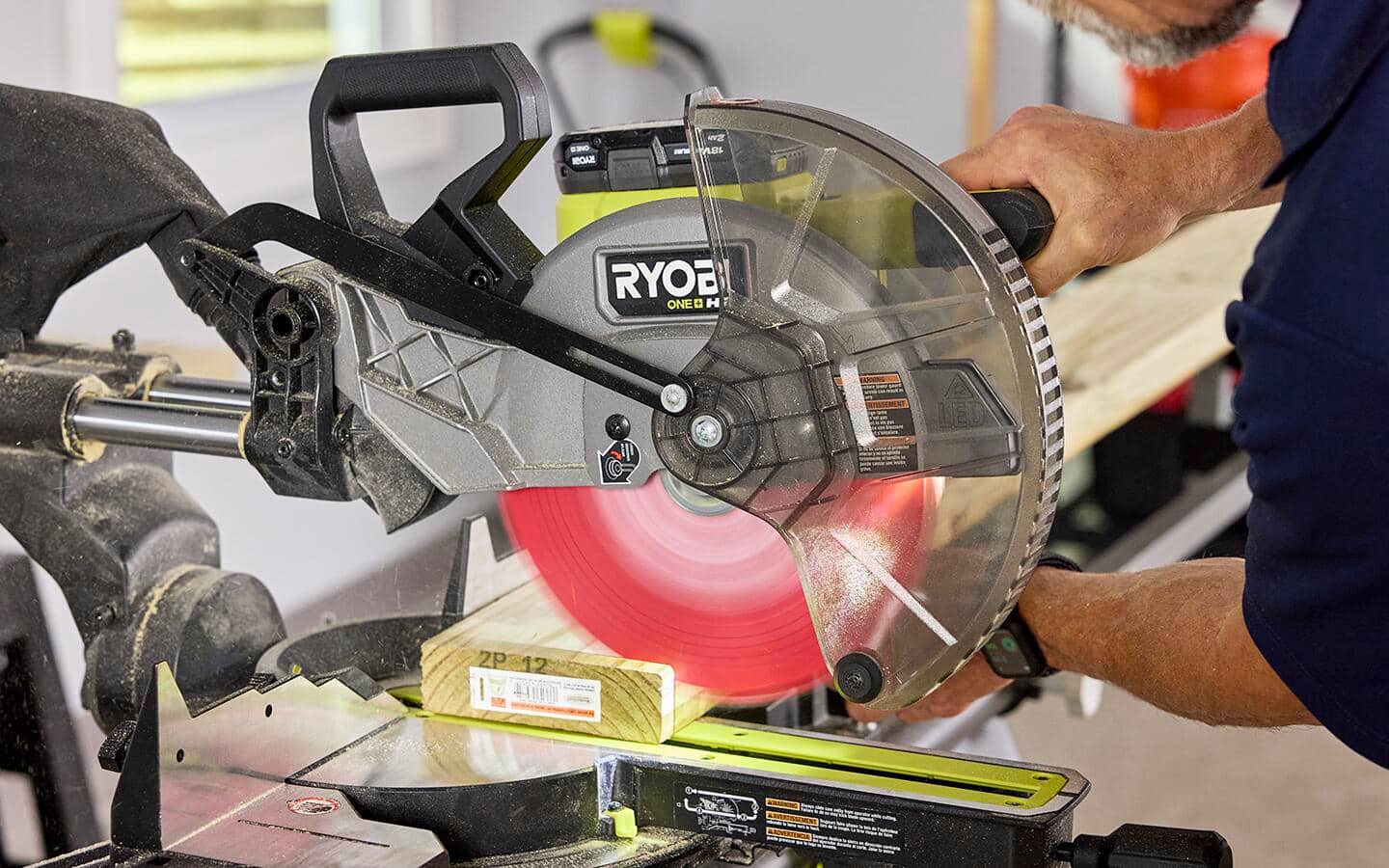 An individual using a miter saw to cut wood casing.