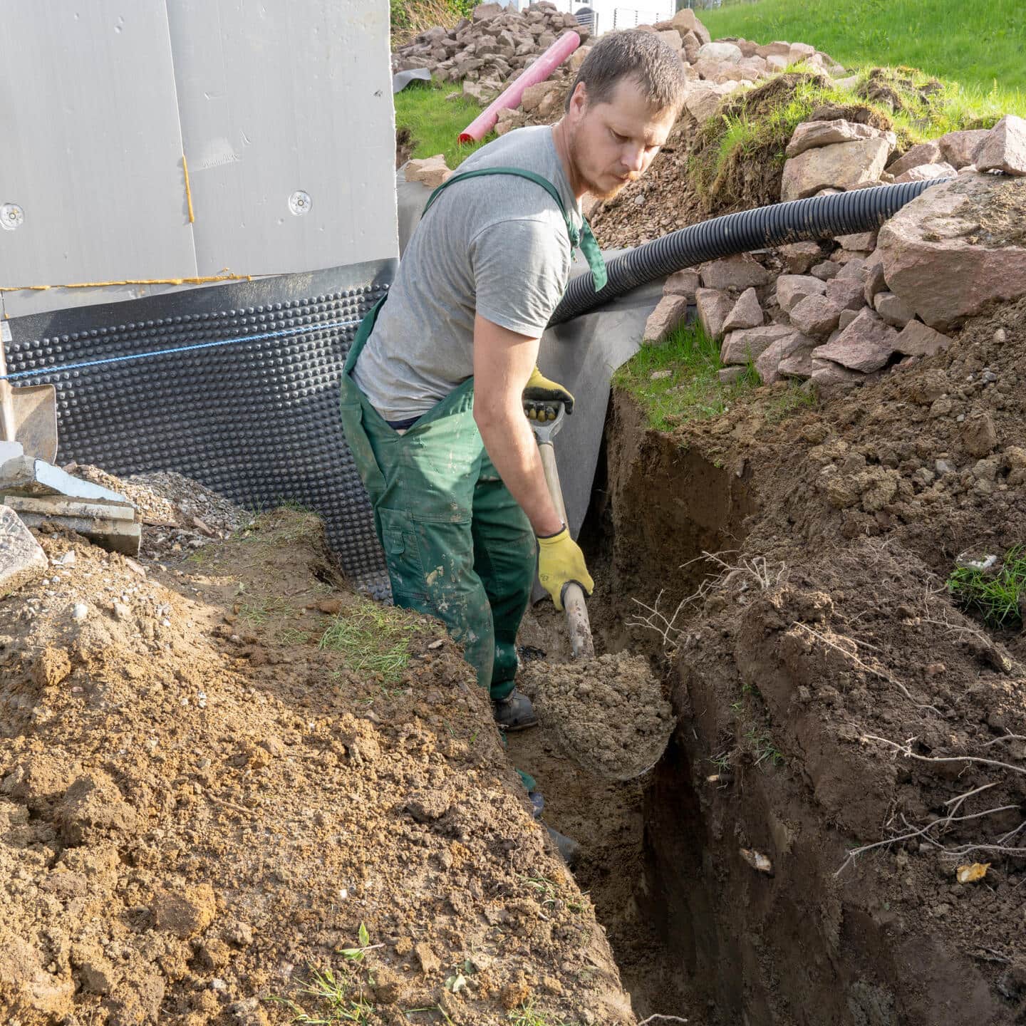 A Pro digs a trench for a French drain.