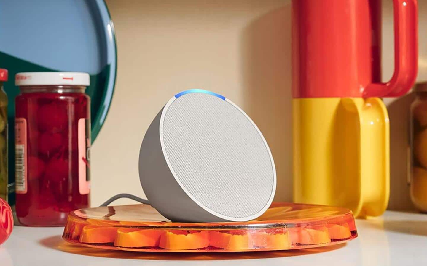 A compact smart speaker with several kitchen items around it to show relative size. A compact smart speaker with several kitchen items around it to show relative size.