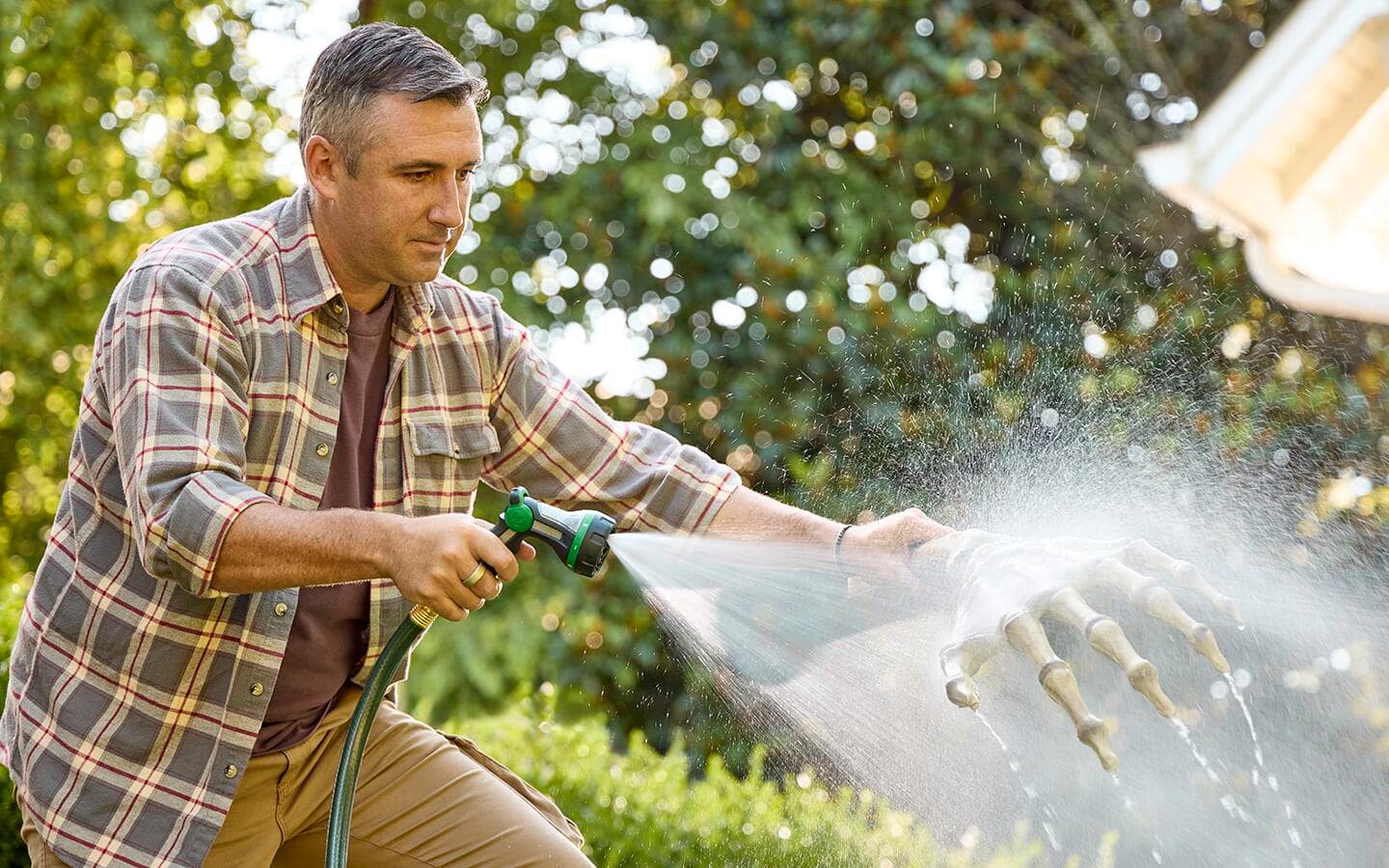 A person uses a water hose to rinse the arm and hand pieces. A person uses a water hose to rinse the arm and hand pieces.