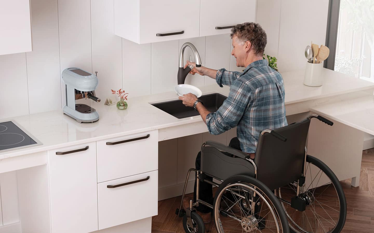A person in a wheelchair works at an ADA-compliant kitchen counter.