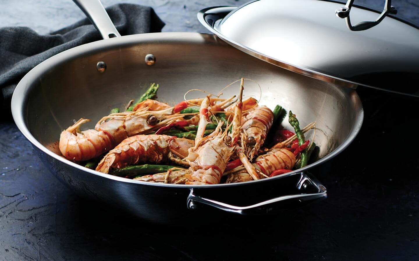 Prawns being cooked in a stainless steel wok with a lid. Prawns being cooked in a stainless steel wok with a lid.