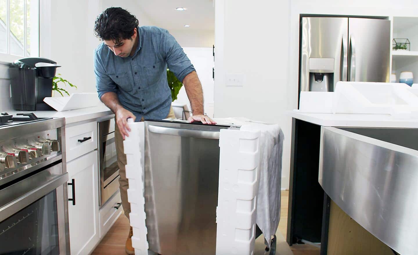 A technician installing a new dishwasher in a kitchen.