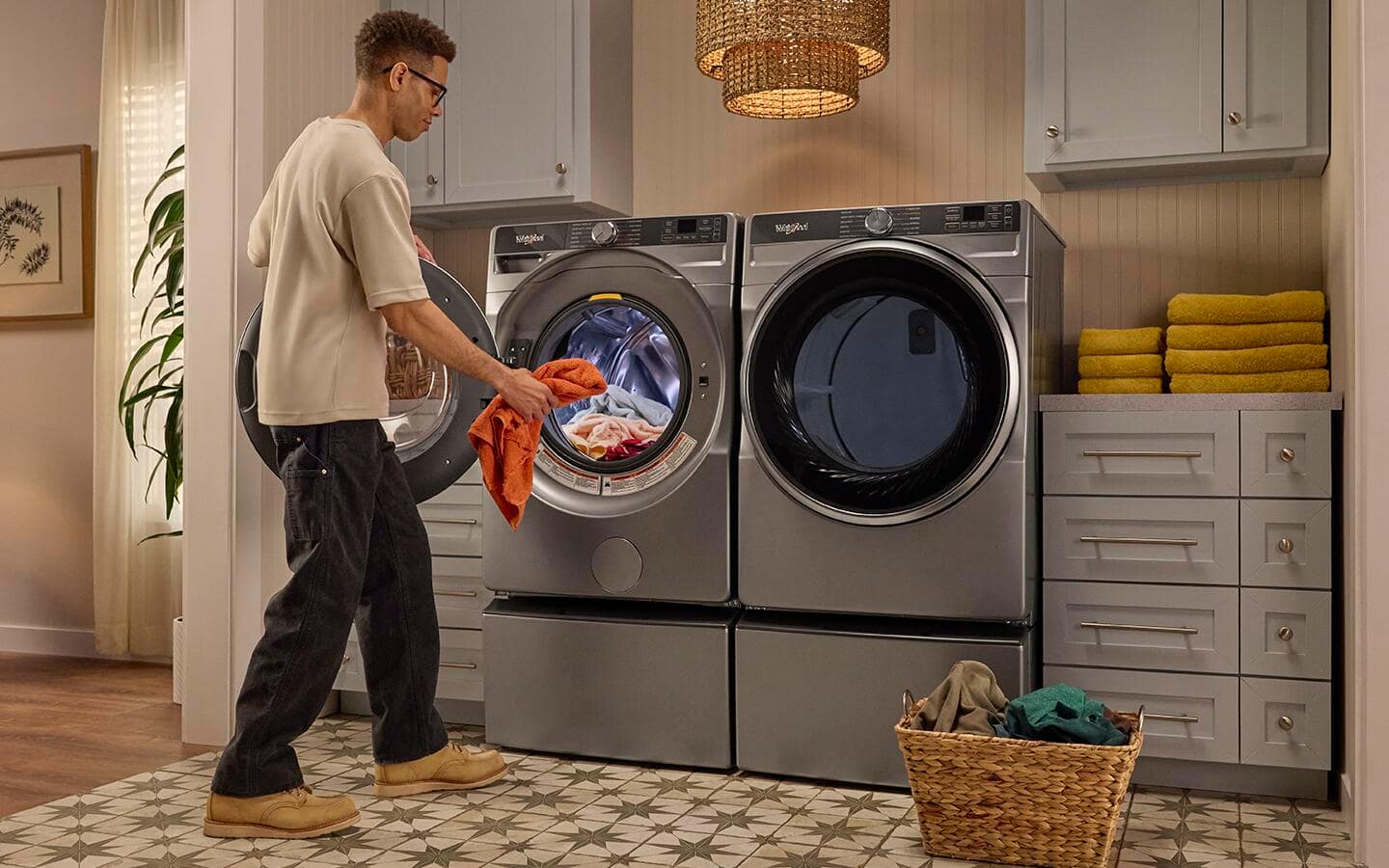 A person adds laundry to a front load washer.