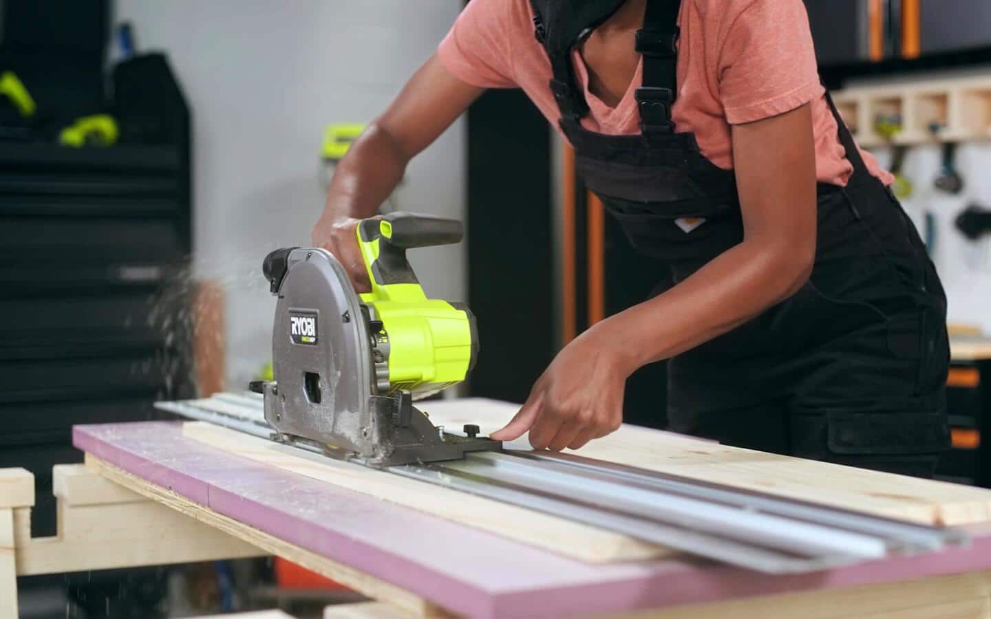 An individual uses a router on a piece of wood in a workshop. An individual uses a router on a piece of wood in a workshop.