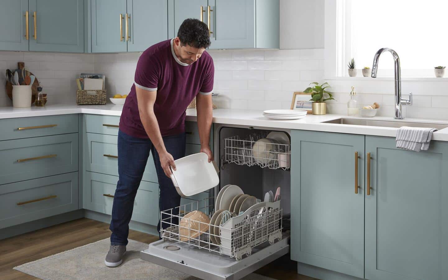 Person loading dishes in a dishwasher Person loading dishes in a dishwasher