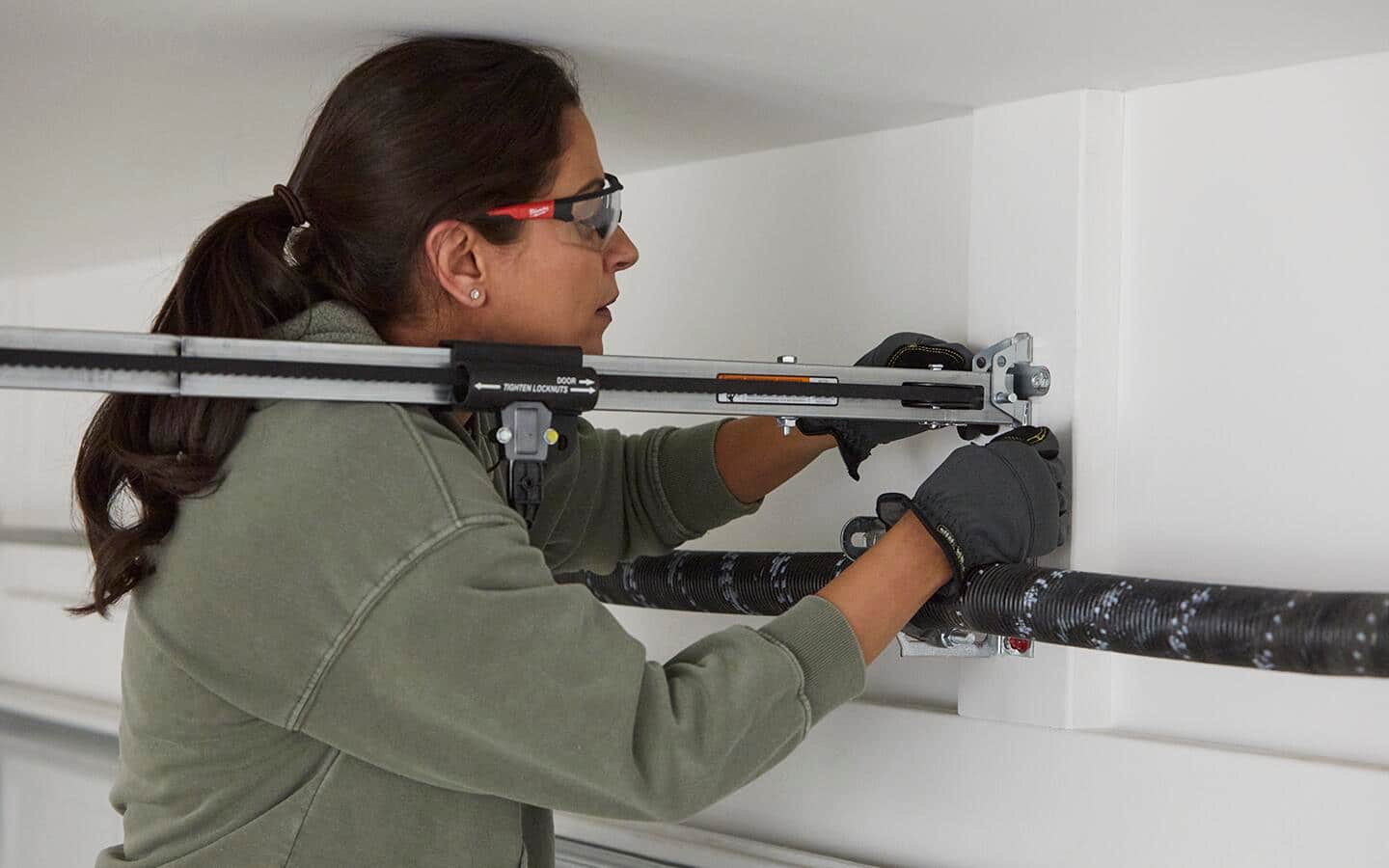 Person mounts the header bracket for a smart garage door opener