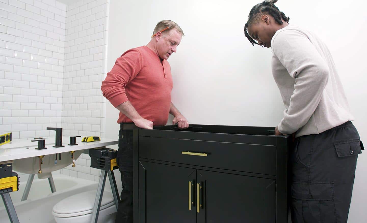 Two people installing a new vanity.