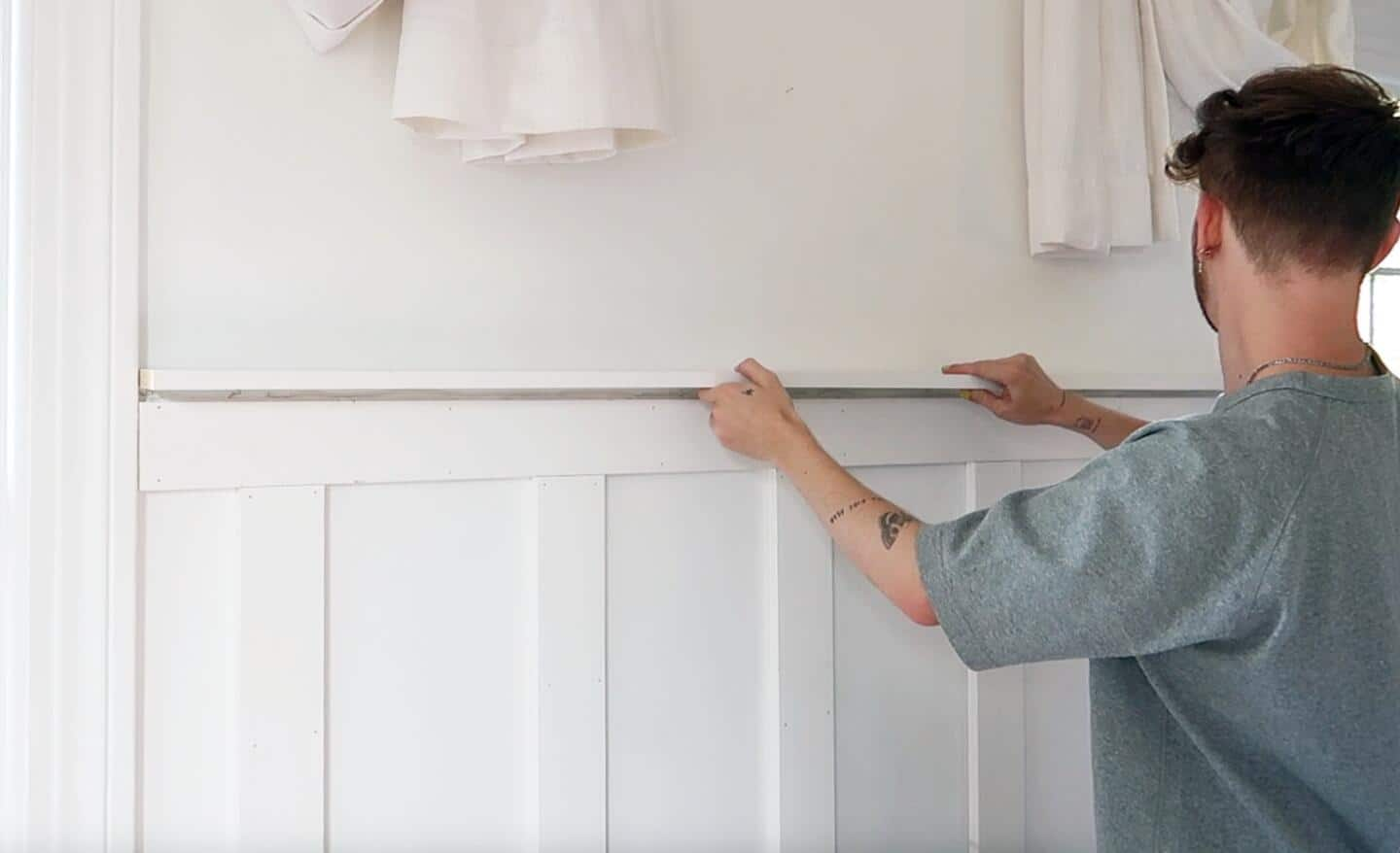 A person placing a horizontal board on top of others.