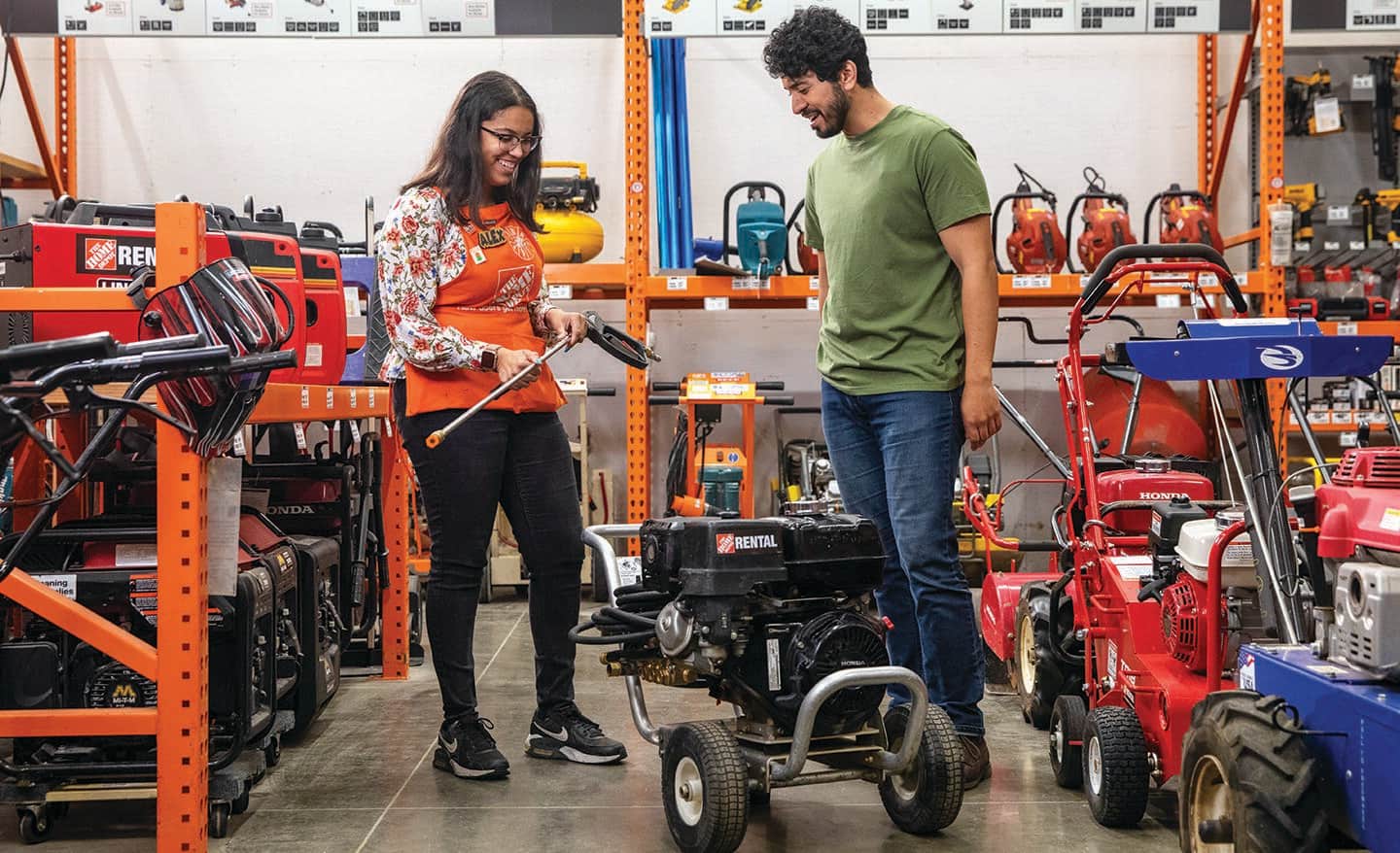 A Home Depot associate and customer discussing renting a pressure washer. 