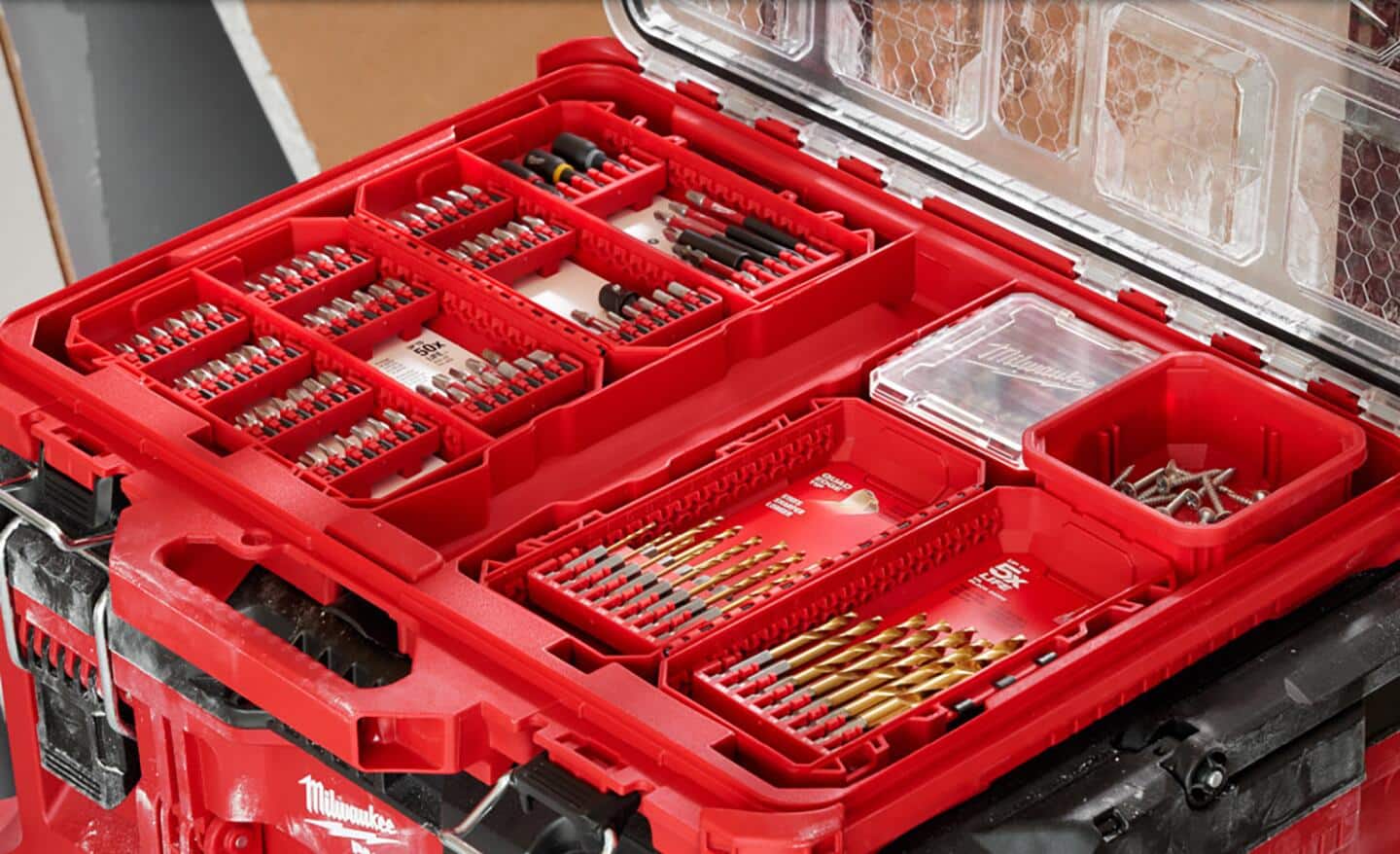 An opened red case shows drill bits stored inside.