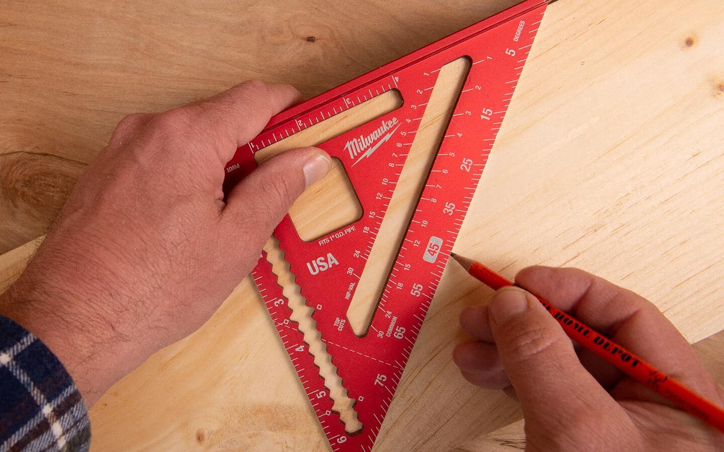 Someone using a layout square to measure a 45-degree miter cut. Someone using a layout square to measure a 45-degree miter cut.