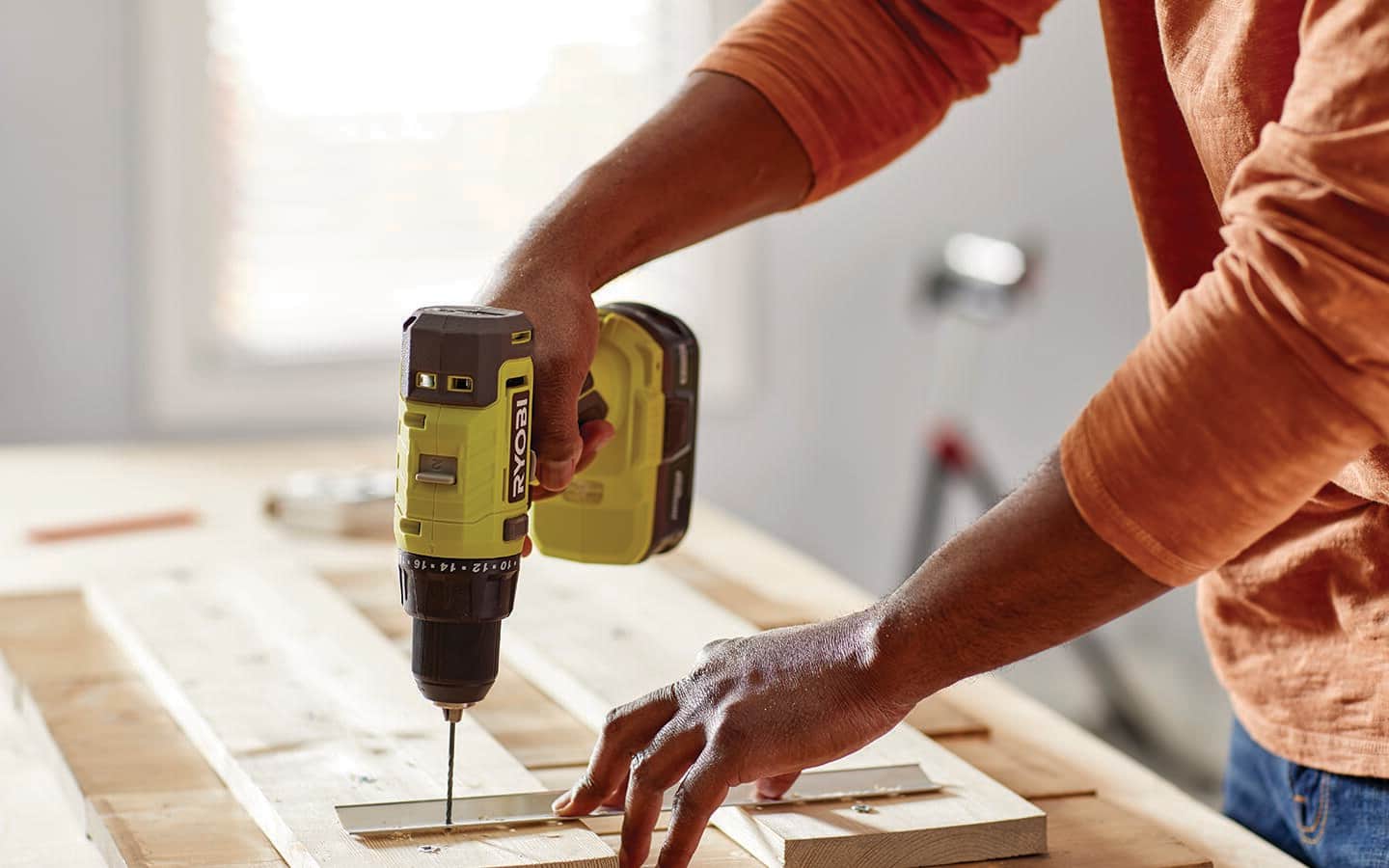A cordless drill attaching French cleats to a Christmas craft board.