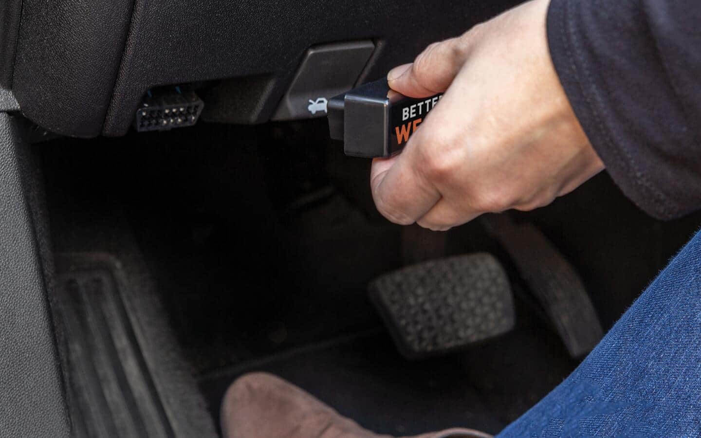 A person connecting a scanning tool to their car. A person connecting a scanning tool to their car.