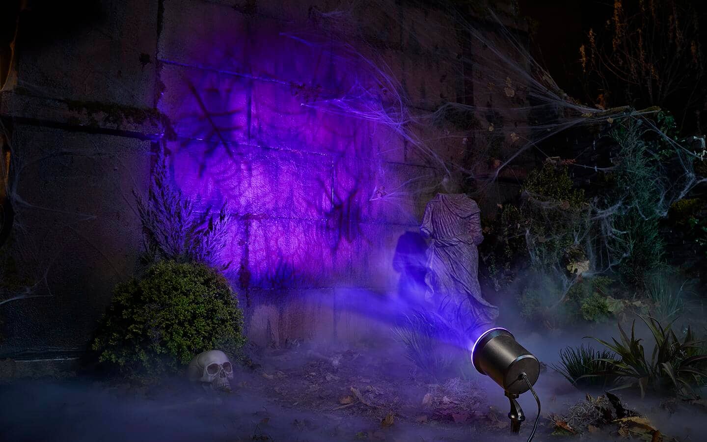 A Halloween light projection featuring spiders in a web