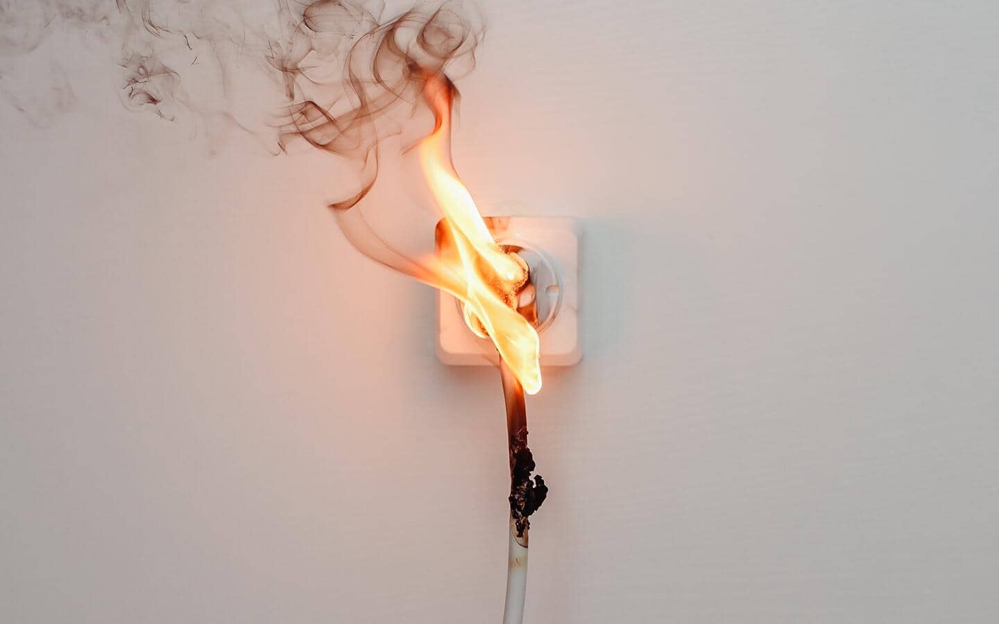A small fire comes out of an outlet where something is plugged in. A small fire comes out of an outlet where something is plugged in.