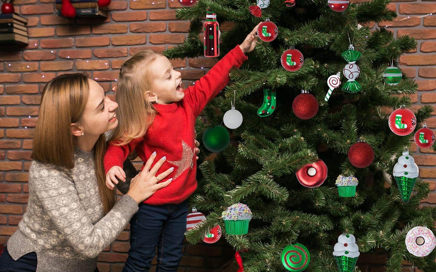 Child hanging ornaments on a Christmas tree. Child hanging ornaments on a Christmas tree.