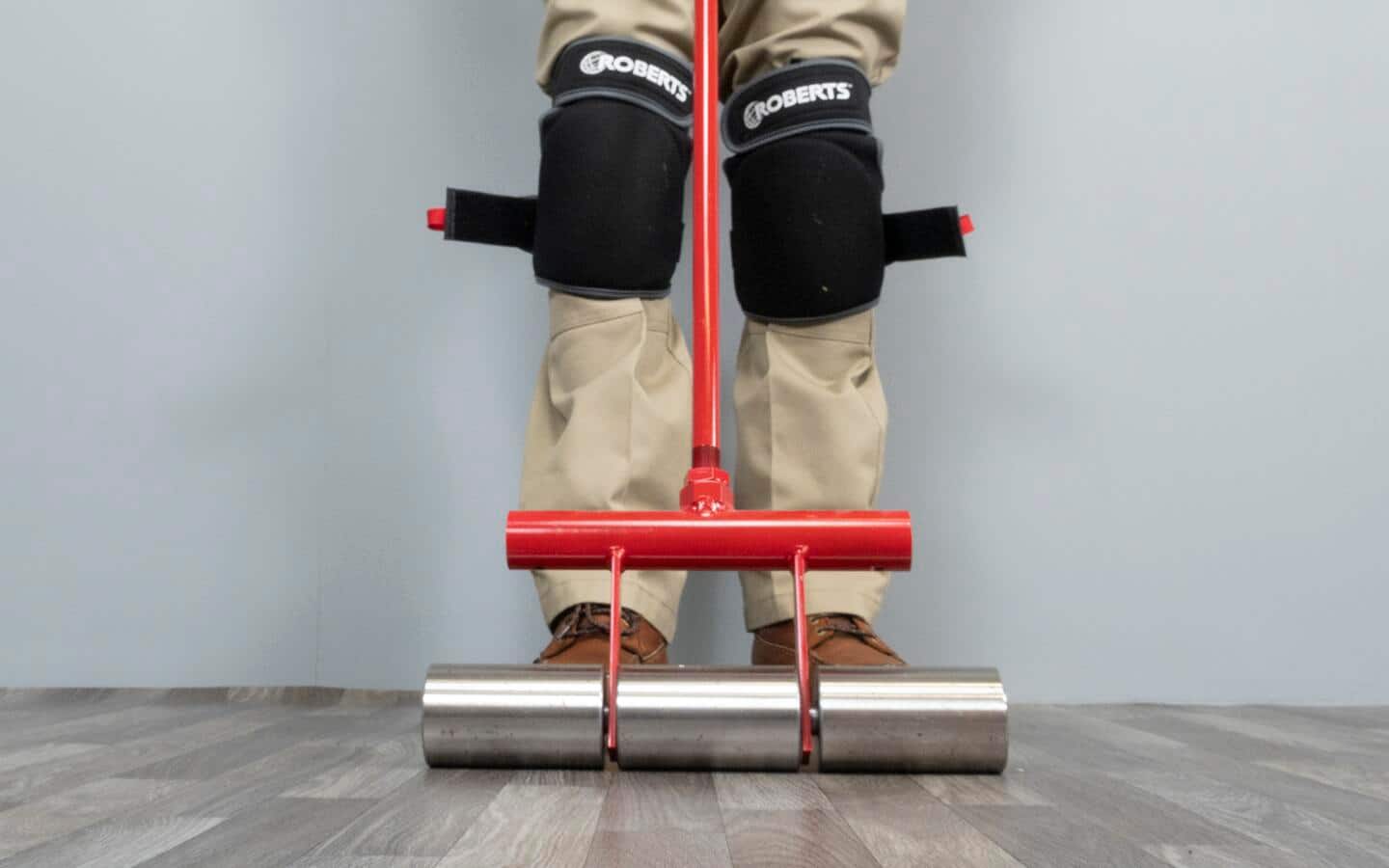A person uses a floor roller in a room. A person uses a floor roller in a room.