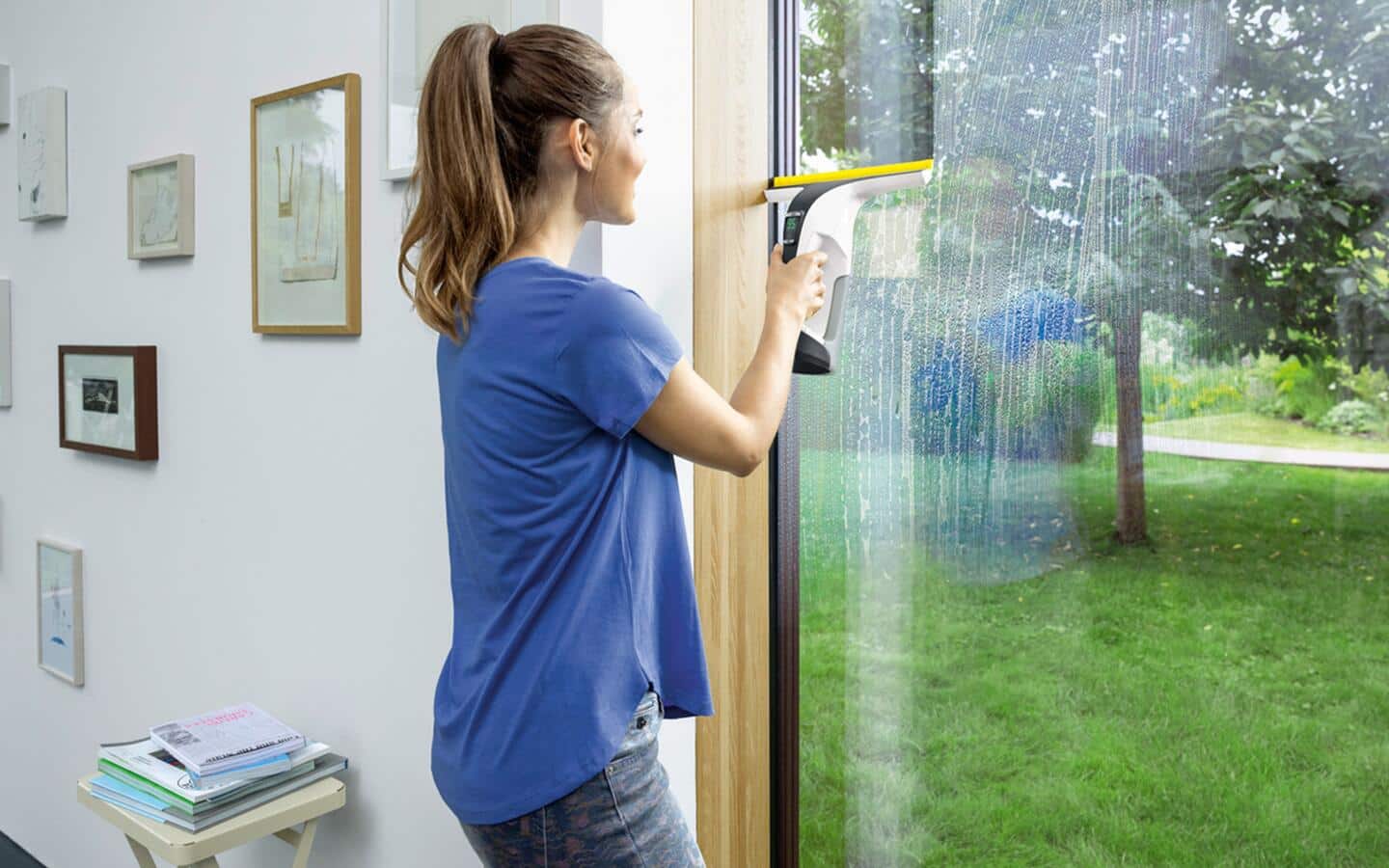 Someone cleaning patio windows with a squeegee.