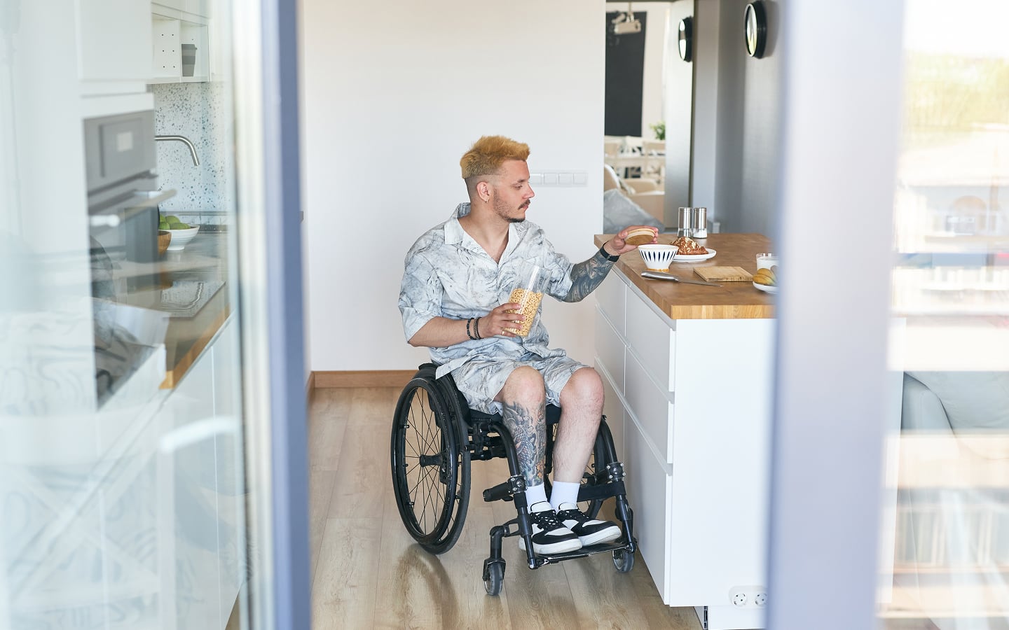 A person in a wheelchair uses an ADA-compliant kitchen counter.