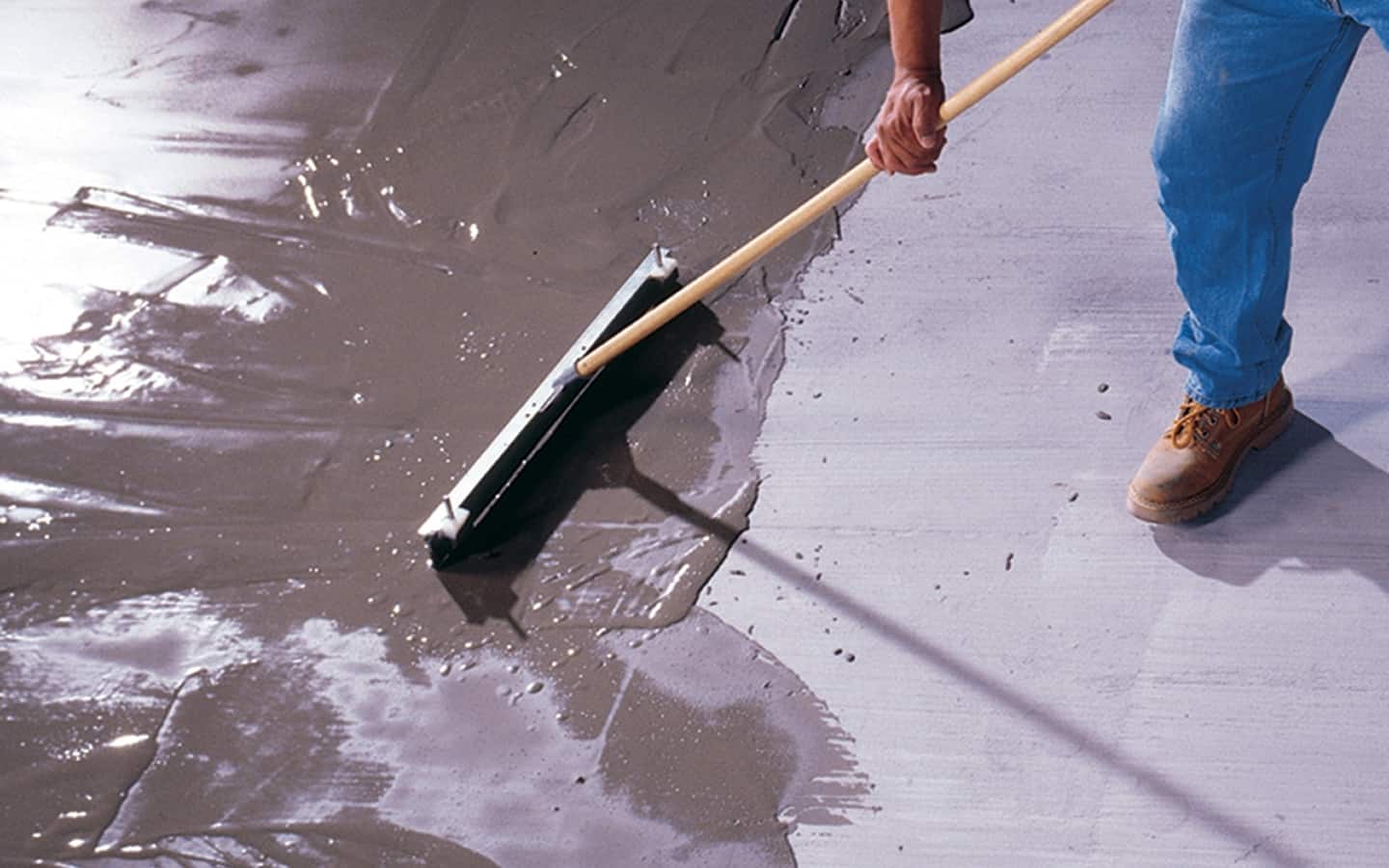 A Pro applying self-leveler over a subfloor.