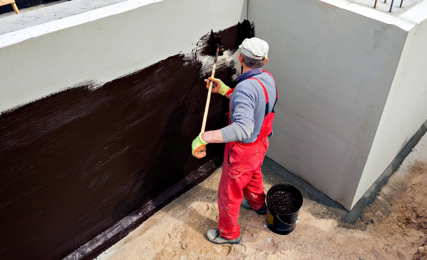 A Pro applies a sealant to a home exterior.