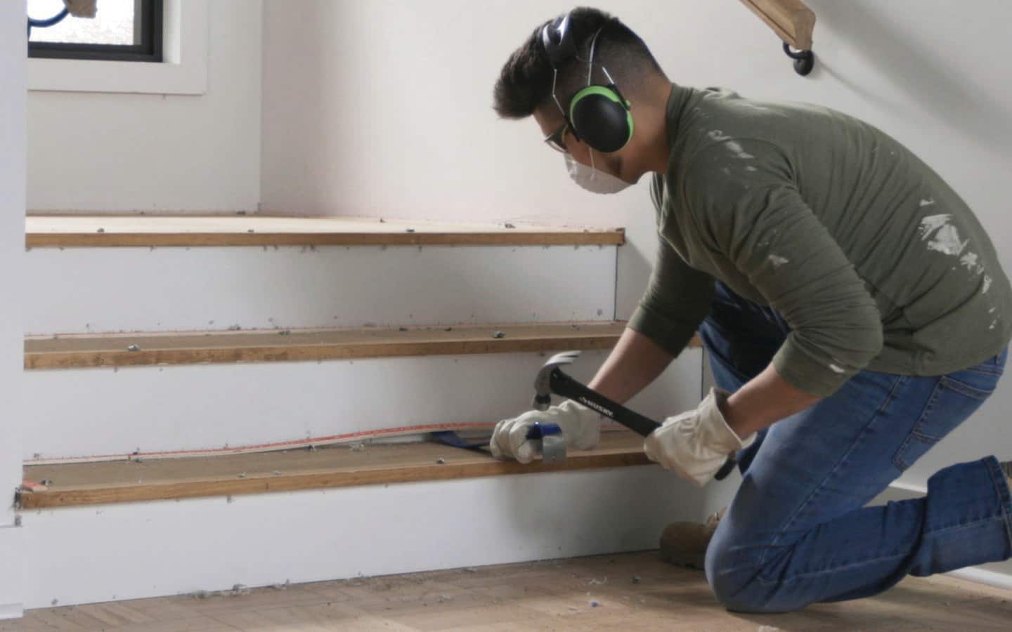 A person removing tack strips from stairs A person removing tack strips from stairs