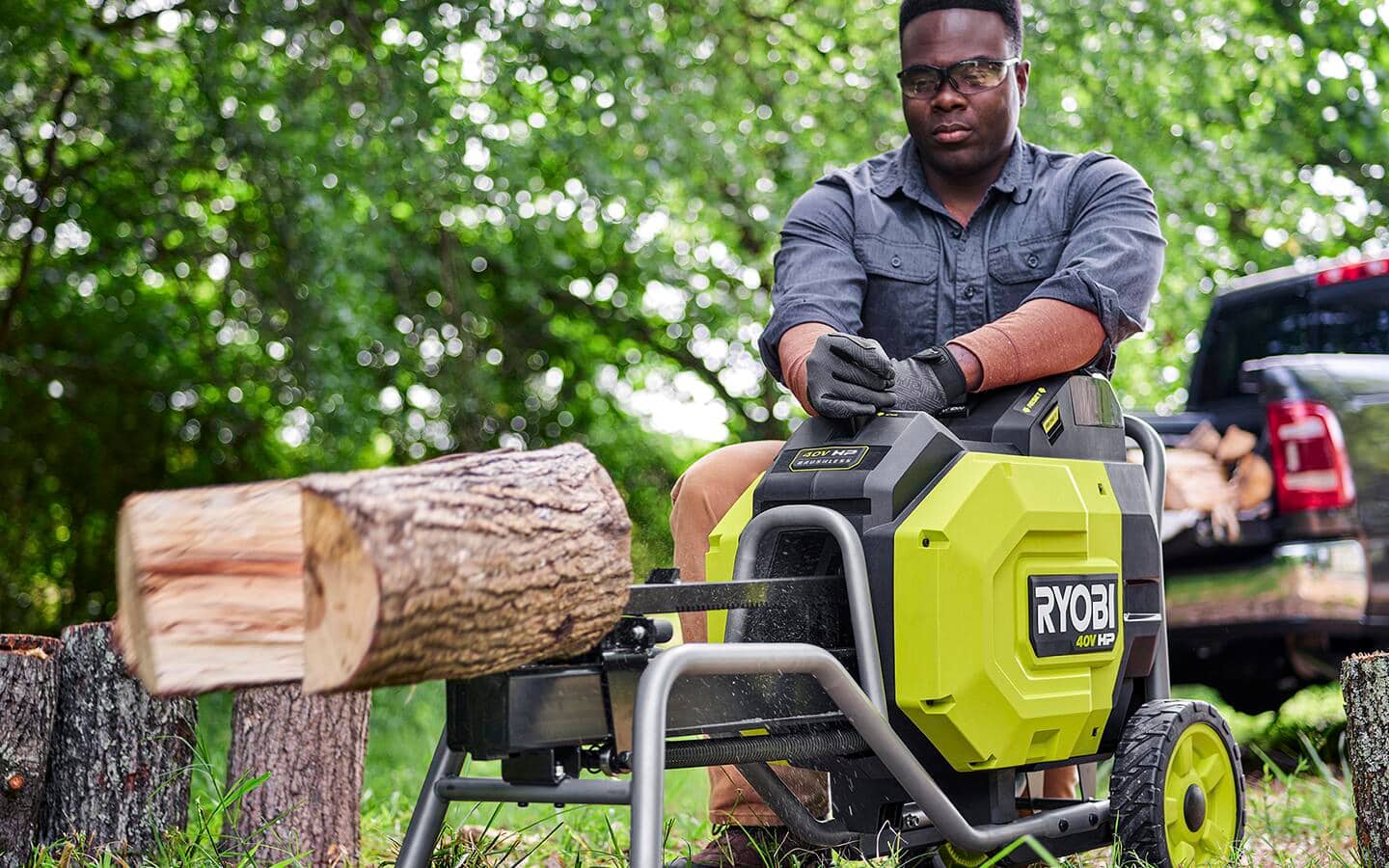 A person using an electric, battery-operated kinetic log splitter A person using an electric, battery-operated kinetic log splitter
