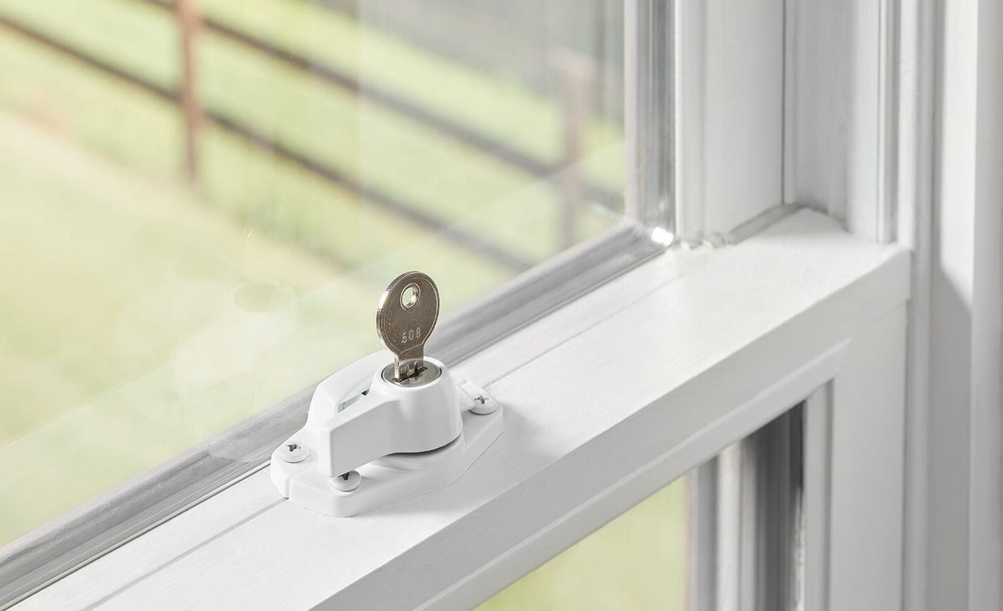 A key stands upright in a window lock.