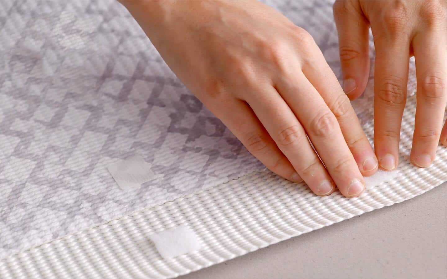A person adds sticky fasteners to a padded envelope. 