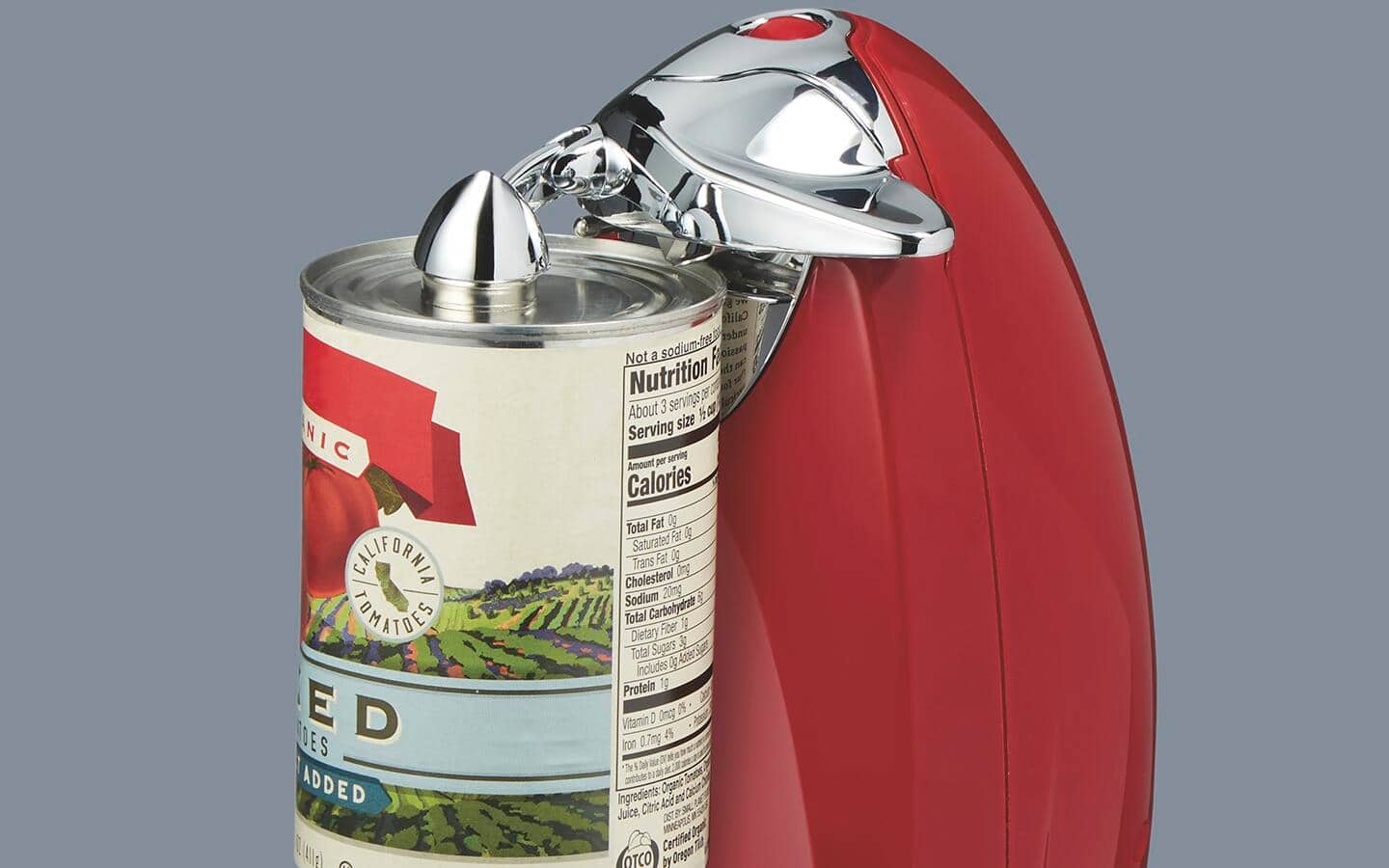 A red can opener on a can. A red can opener on a can.