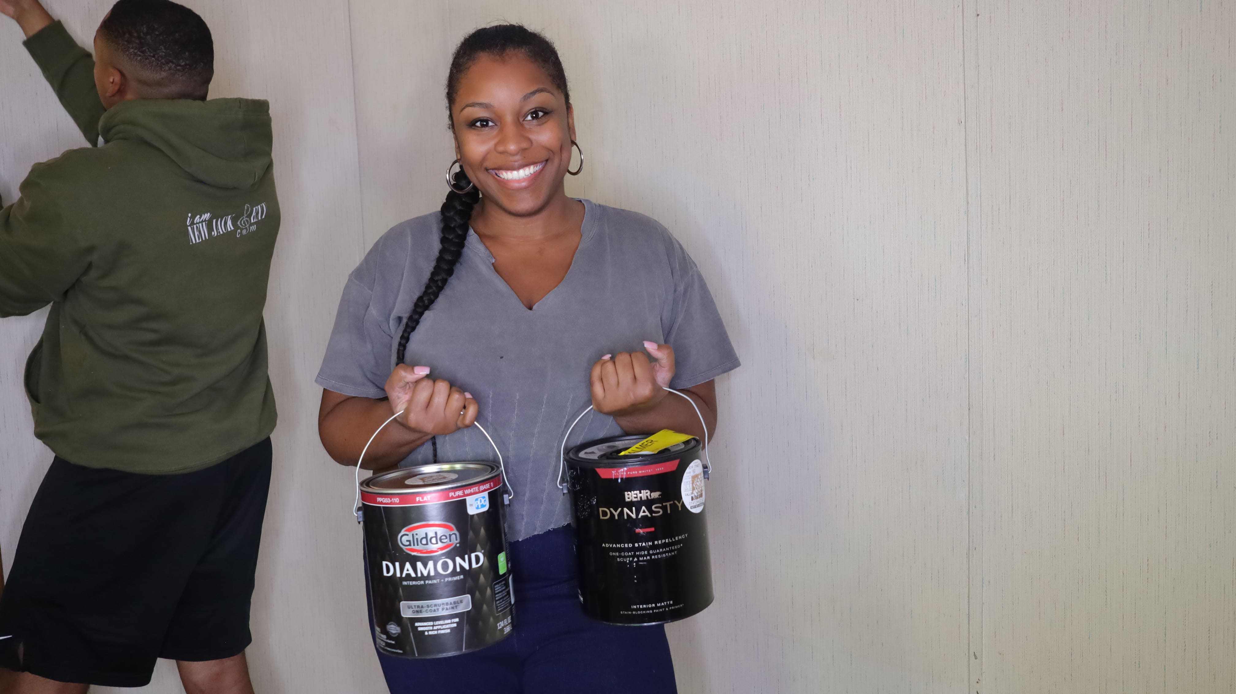 A woman holding two paint cans.