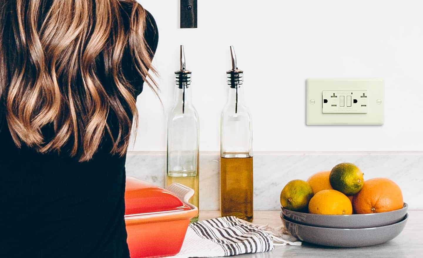 A GFCI outlet placed on a wall next to a kitchen counter.