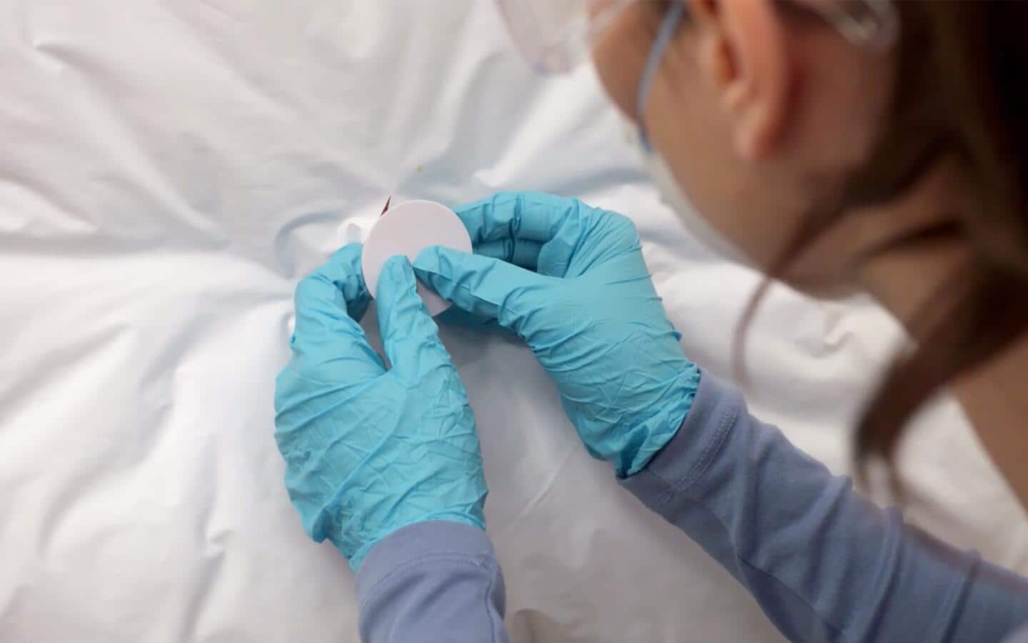 A person securing insulation with a retention clip.