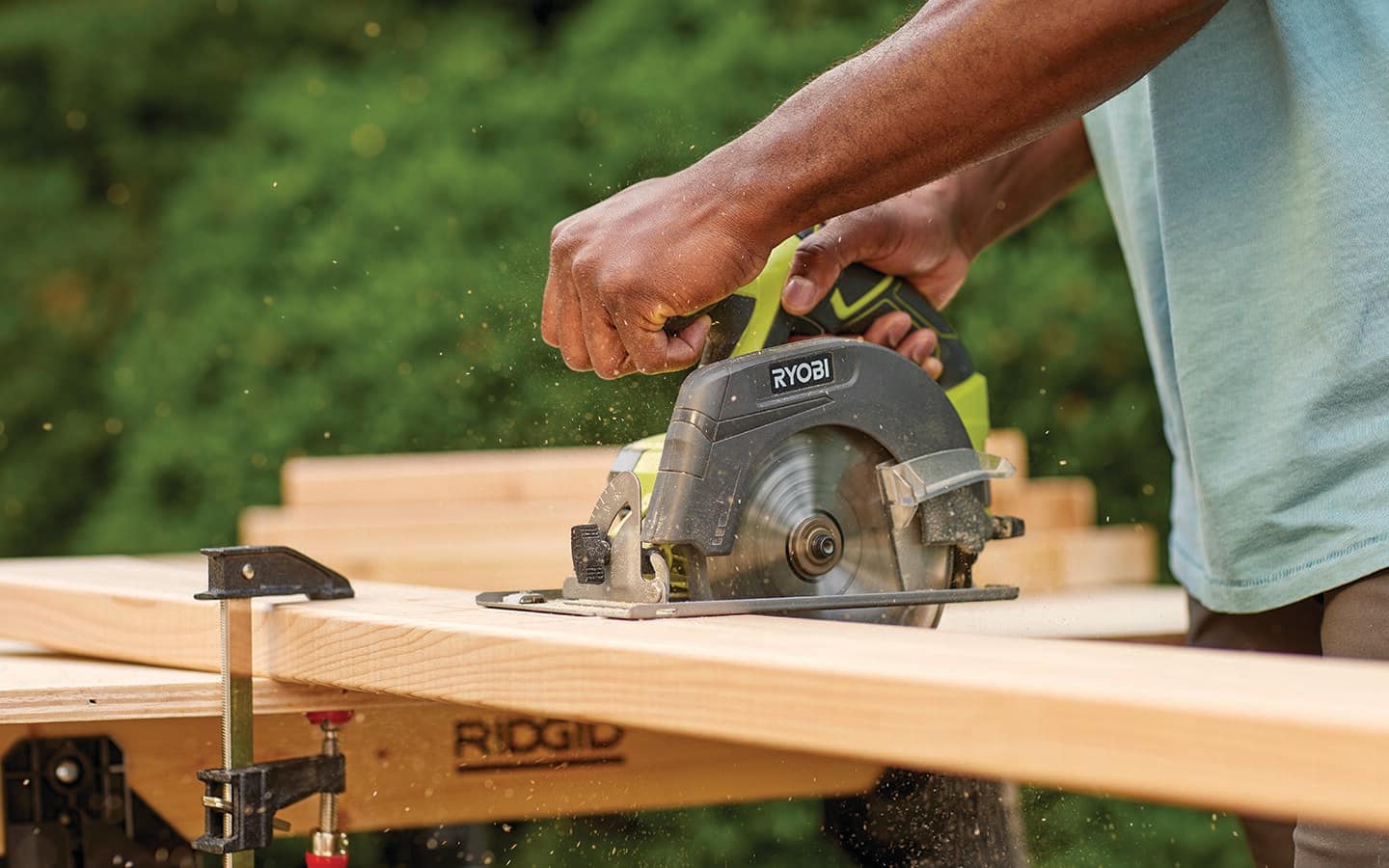 A person cuts a board with a circular saw.