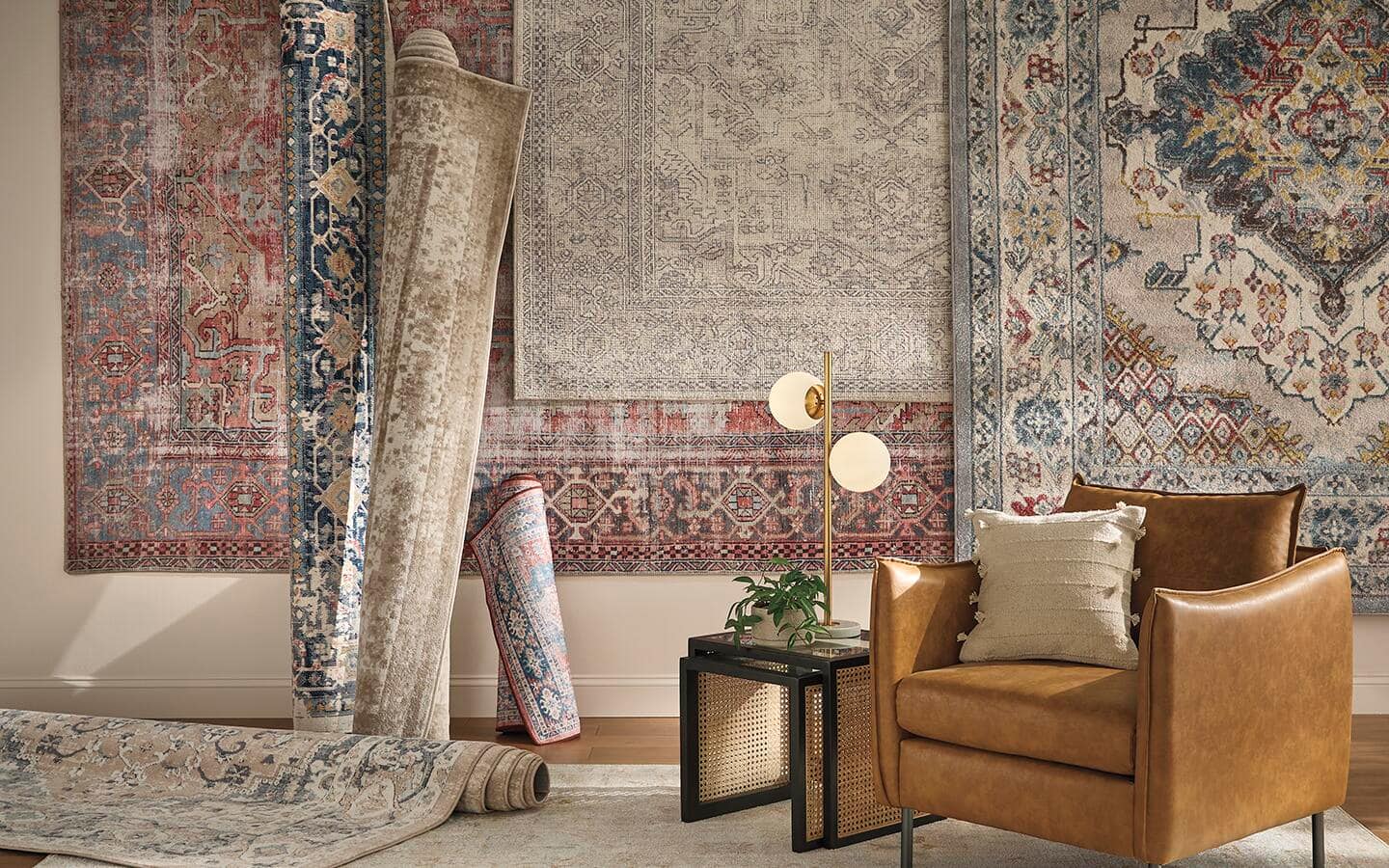 Different styles and sizes of area rugs hanging on a wall.