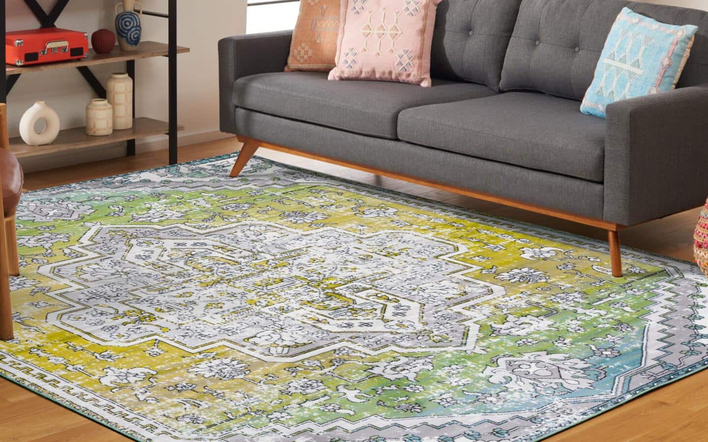 A overdyed rug lays under a couch and a chair.